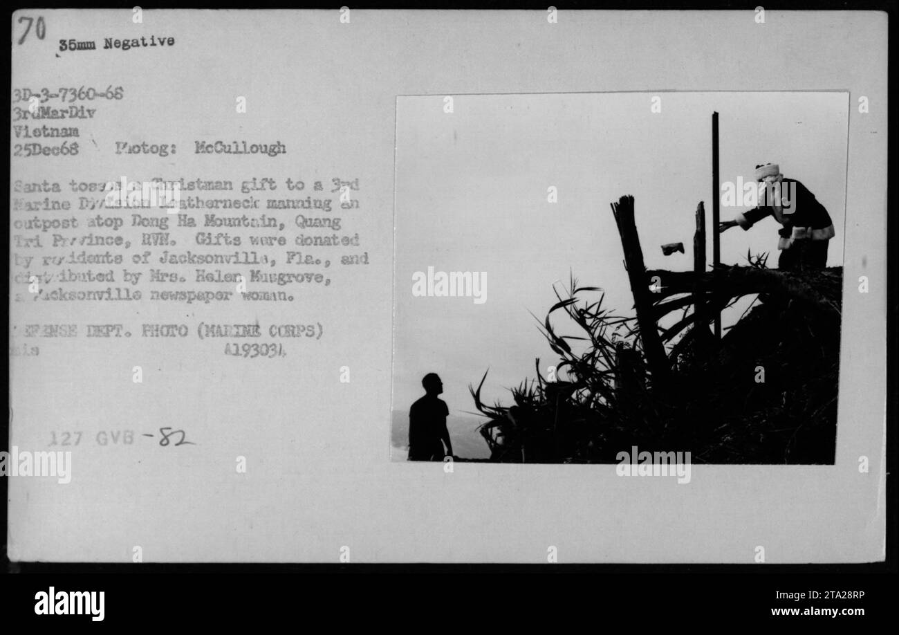 Der Weihnachtsmann wirft ein Weihnachtsgeschenk an einen Soldaten der 3. Marine-Division auf dem Berg Dong Ha, Provinz Quang Tri, RVN, am 25. Dezember 1968. mit Geschenken, die von Einwohnern von Jacksonville gespendet wurden. Stockfoto