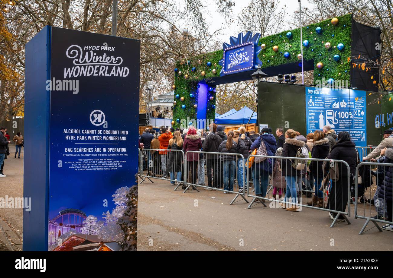 Die Leute stehen an, um den jährlichen Freizeitpark „Winter Wonderland“ zu betreten, der rund um Weihnachten im Hyde Park, London, Großbritannien, stattfindet. Stockfoto