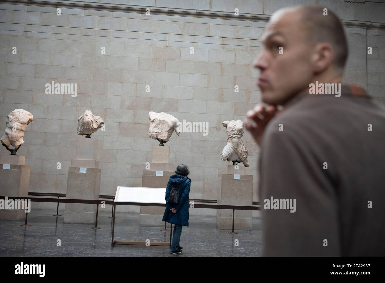 Besucher des Londoner British Museum bewundern den Pferdekopf, eines der antiken griechischen Parthenon-Metope, auch bekannt als Parthenon (Elgin) Marbles, am 28. November 2023 in London, England. Der Pferdekopf zog einst den Wagen der Mondgottin Selene. Zweiundneunzig Metope waren rechteckige Marmorplatten, die über den Säulen des Athener Parthenon-Tempels aufgestellt wurden und Szenen aus der griechischen Mythologie darstellen. Stockfoto