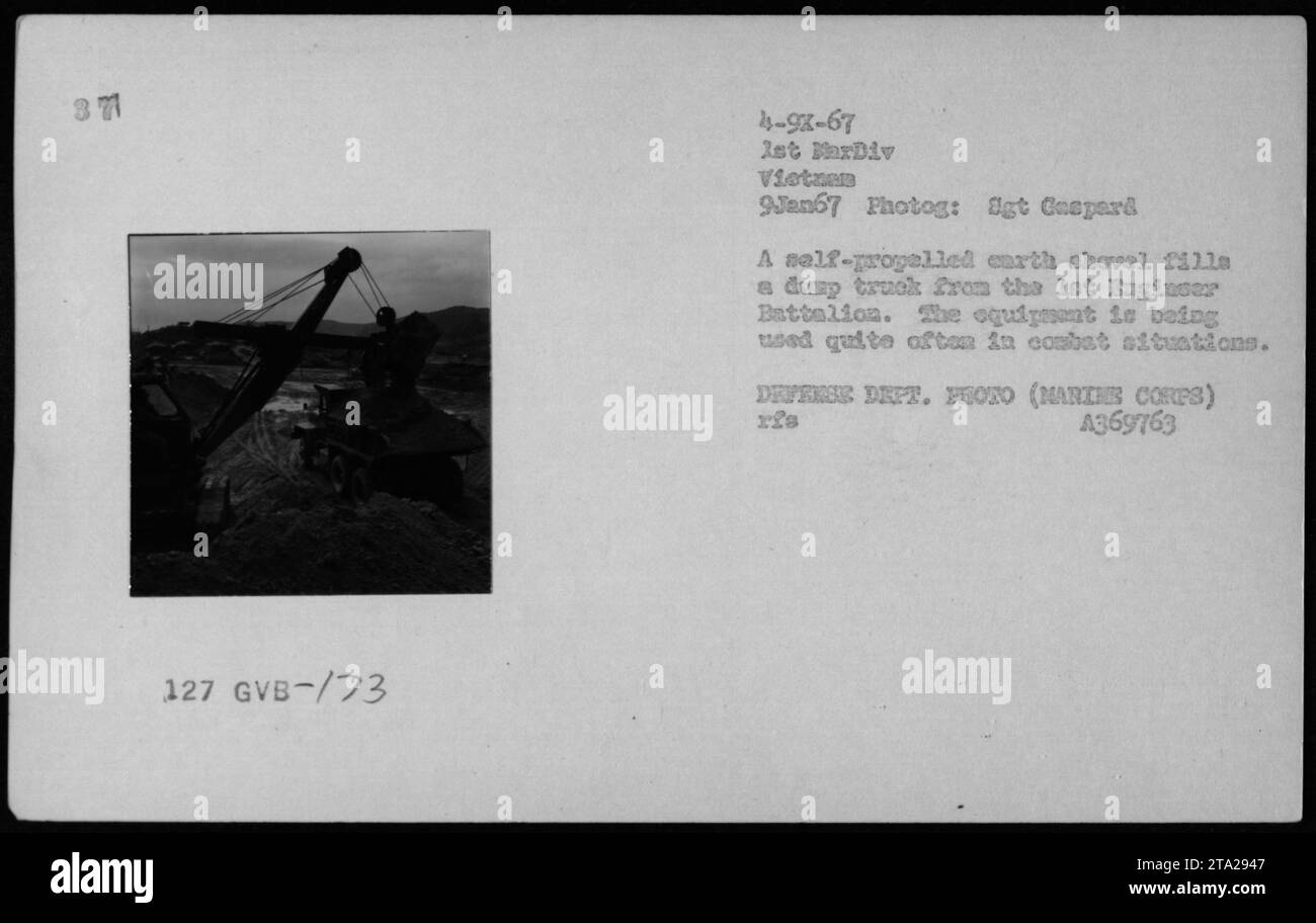 Eine selbstfahrende Erdschaufel des Bataillons Lot Baginser lädt während der Bauarbeiten in Vietnam am 9. Januar 1967 einen Müllwagen, der die militärische Logistik und Kampftechnik unterstützt. Stockfoto