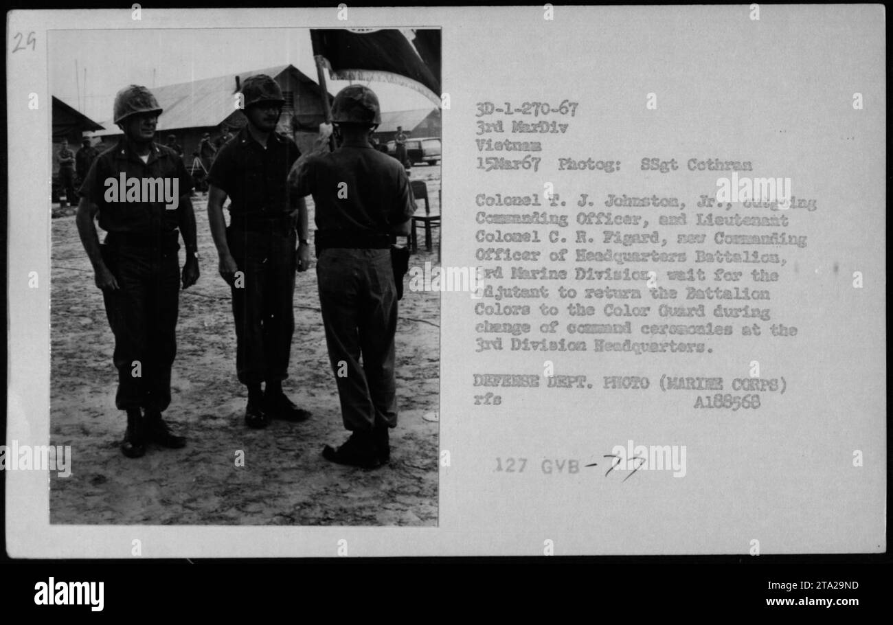 Colonel T. J. Johnston, Jr., scheidender Kommandant, und Lieutenant Colonel C. R. Figard, neuer Kommandant des Hauptquartierbataillons der 3. Marine-Division, warten darauf, dass der Adjutant die Colors des Bataillons an die Color Guard zurückgibt, während der Kommandowechsel im Hauptquartier der 3. Division stattfindet. Foto am 15. März 1967. Stockfoto