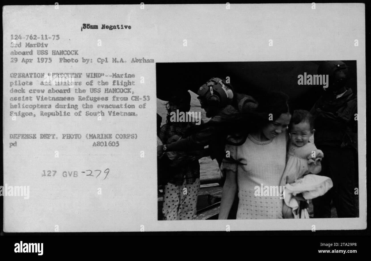 Marine-Piloten und Flugdeckbesatzung an Bord der USS Hancock unterstützen vietnamesische Flüchtlinge aus CH-53 Hubschraubern während der Evakuierung der Operation Frequent Wind am 29. April 1975. Stockfoto