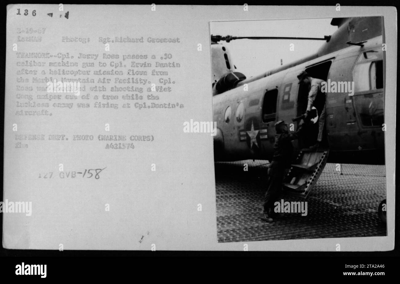 Während des Vietnamkriegs demonstrieren die Marines Teamwork, als Jerry Roes ein Maschinengewehr des Kalibers .50 an CPL Ervin Dantin übergibt. Die Marines wurden von der Marble Mountain Air Facility in einem Hubschrauber geflogen. CPL. Dantins Flugzeug wurde von einem vietnamesischen Scharfschützen beschossen, den CPL. Ross effektiv eliminierte. (Foto Des Verteidigungsministeriums, Marine Corps, 4621574) Stockfoto