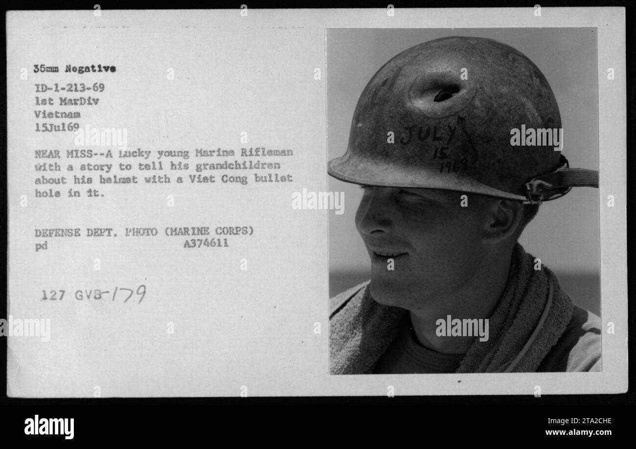 Ein US-Marine aus der 1. Marine-Division im Vietnamkrieg zeigt seinen Helm, der von einer Kugel eines Viet Cong-Beinaheunfalls durchbohrt wurde. Dieses Foto, aufgenommen am 15. Juli 1969, zeigt das glückliche Überleben der Marine und erinnert an die Intensität des Kampfes während des Konflikts. Stockfoto