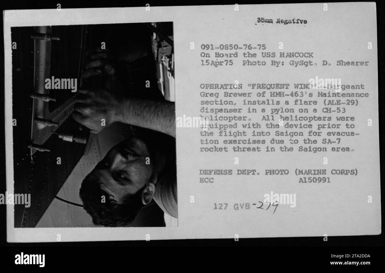 Sergeant Greg Brewer von HMH-463 Maintenance installiert am 15. April 1975 einen Fackelspender an einem CH-53-Hubschrauber an Bord der USS Hancock, während der Operation häufige Windevakuierung aufgrund von SA-7-Raketendrohungen. Stockfoto