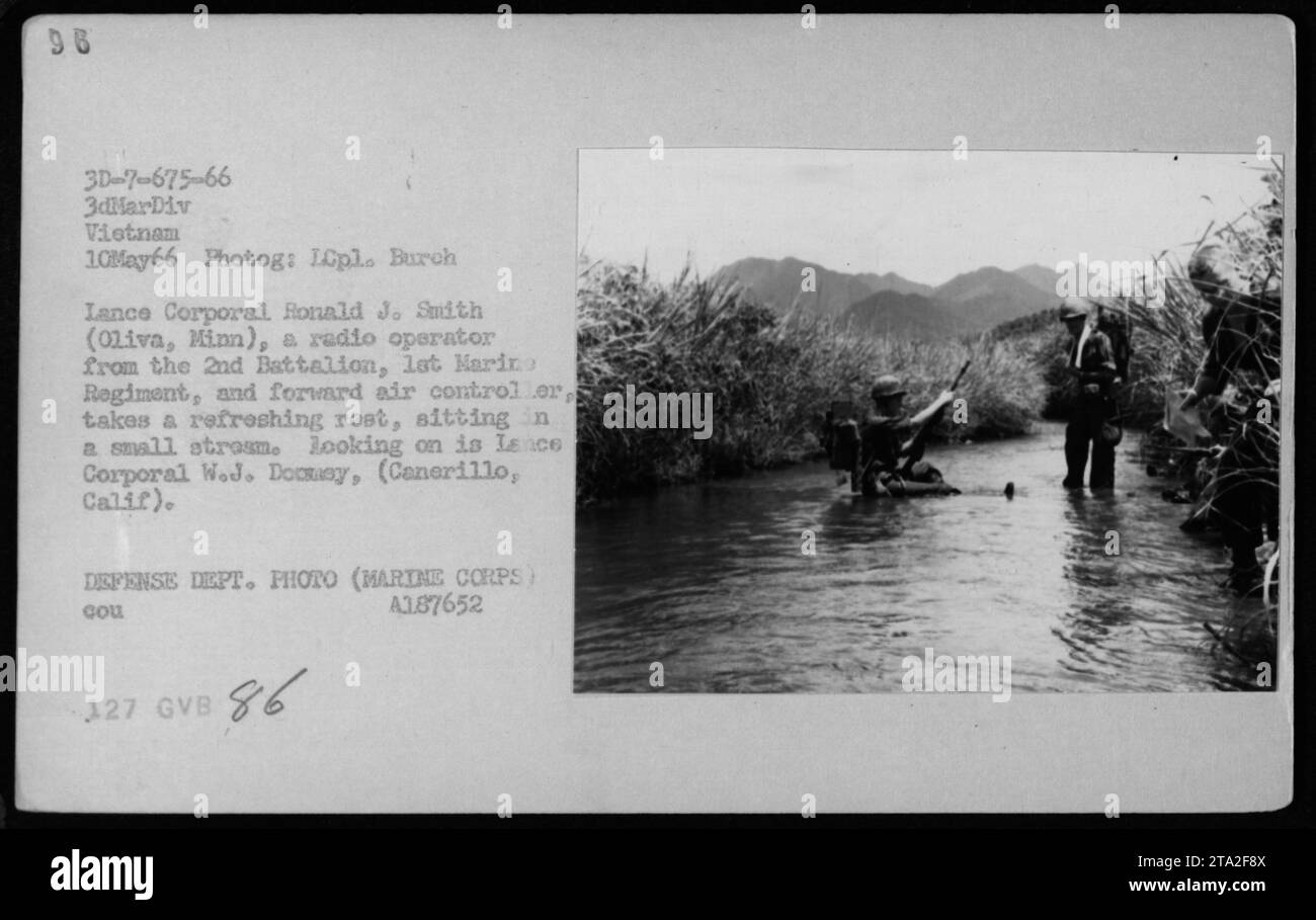 Lance Corporal Ronald J. Smith vom 2. Bataillon, 1. Marine-Regiment in Vietnam, macht eine Pause in einer kleinen Struktur, während er als Funk-Operator und Forward Air Controller dient. Lance Corporal W.J. Docsy beobachtet aus der Nähe. Dieses Foto wurde am 10. Mai 1966 von LCpl aufgenommen. Burch und ist Teil der amerikanischen Militäreinsätze während des Vietnamkriegs. Stockfoto