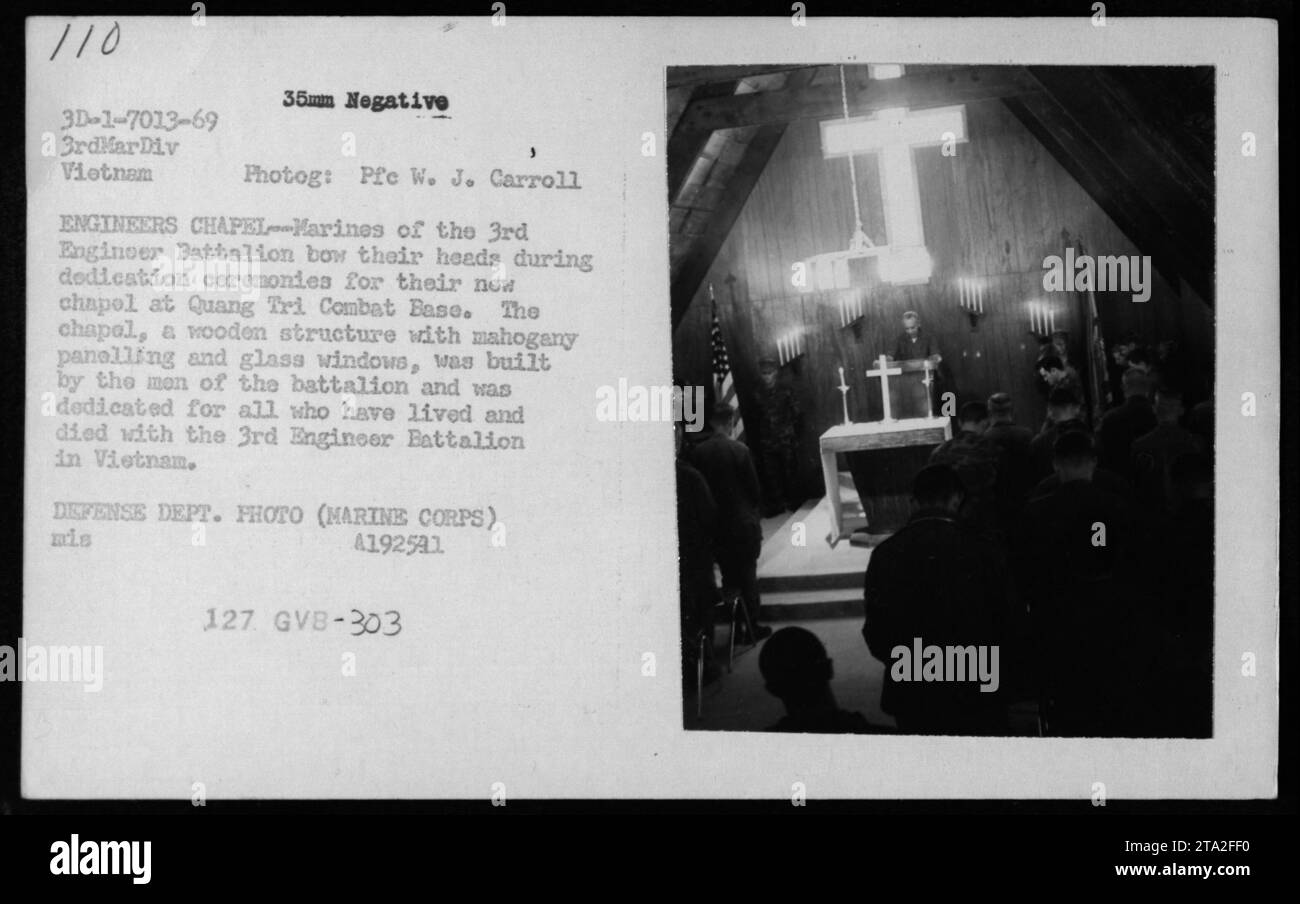 Marines des 3. Ingenieur-Bataillons nehmen 1969 an der Weihungszeremonie für ihre neue Kapelle auf der Quang Tri Combat Base Teil. Die Kapelle, die vom Bataillon errichtet wurde, ist ein Holzbau mit Mahagoni-Vertäfelung und Glasfenstern. Dieses Bild fängt einen Moment des Gebets und der Reflexion ein, während die Männer ihre Köpfe beugen. Stockfoto