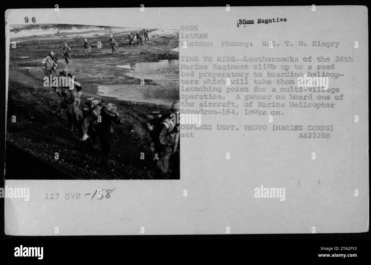 Die Marines des 26. Marine-Regiments bereiten sich darauf vor, an Bord von Hubschraubern für eine mehrdörfliche Operation während des Vietnamkriegs zu gehen. Ein Schütze der Marine Helicopter Squadron-164 beobachtet aus dem Flugzeug, wie die Truppen ein Straßenbett erklimmen. Stockfoto