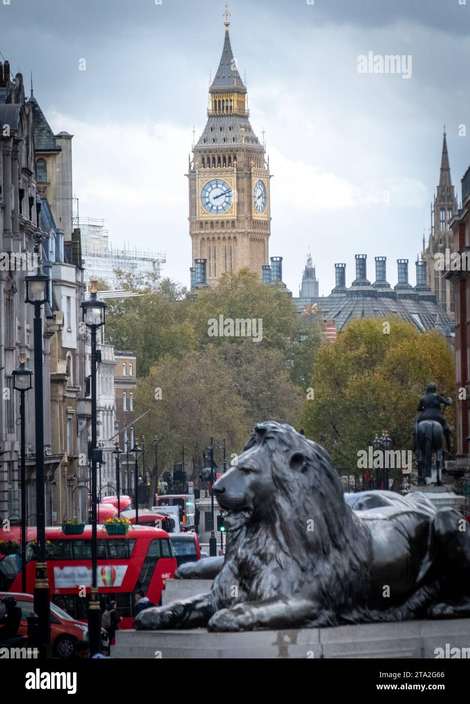 LONDON, 13. NOVEMBER 2023: Big Ben oder Elizabeth Tower hinter einer der Löwenstatuen auf dem Trafalgar Square. Eine berühmte Londoner Wahrzeichen-Szene Stockfoto