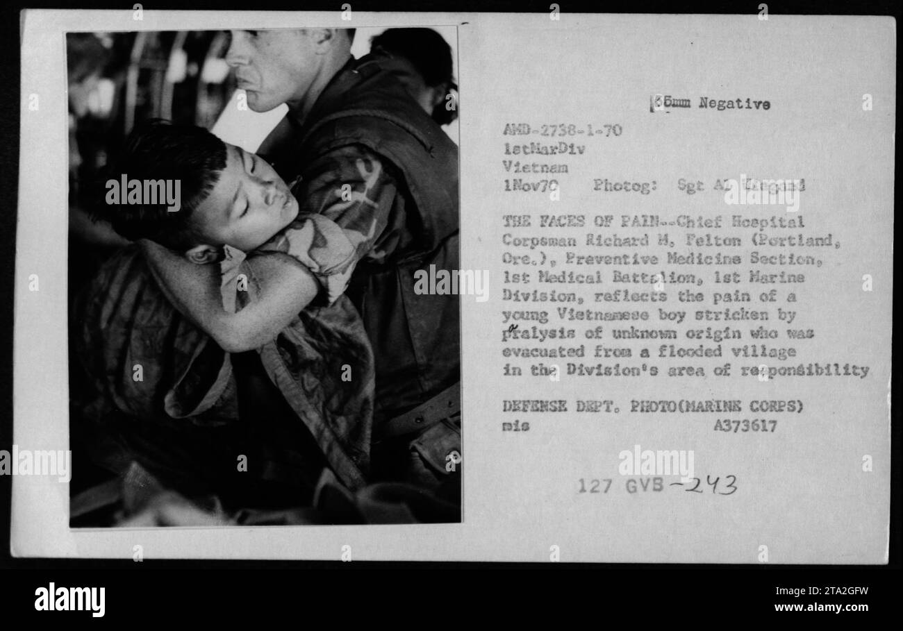 Titel: Evakuierung von Zivilisten - 1. November 1970 Bildunterschrift: Chief Hospital Corpsman Richard H. Felton von der 1st Marine Division reflektiert die Schmerzen auf seinem Gesicht, während er einen jungen vietnamesischen Jungen tröstet, der an Lähmungen unbekannter Herkunft leidet. Der Junge wurde aus einem überfluteten Dorf im Verantwortungsbereich der Division gerettet und evakuiert. (Foto von Sgt A1 Wiegand, 1. November 1970) Stockfoto