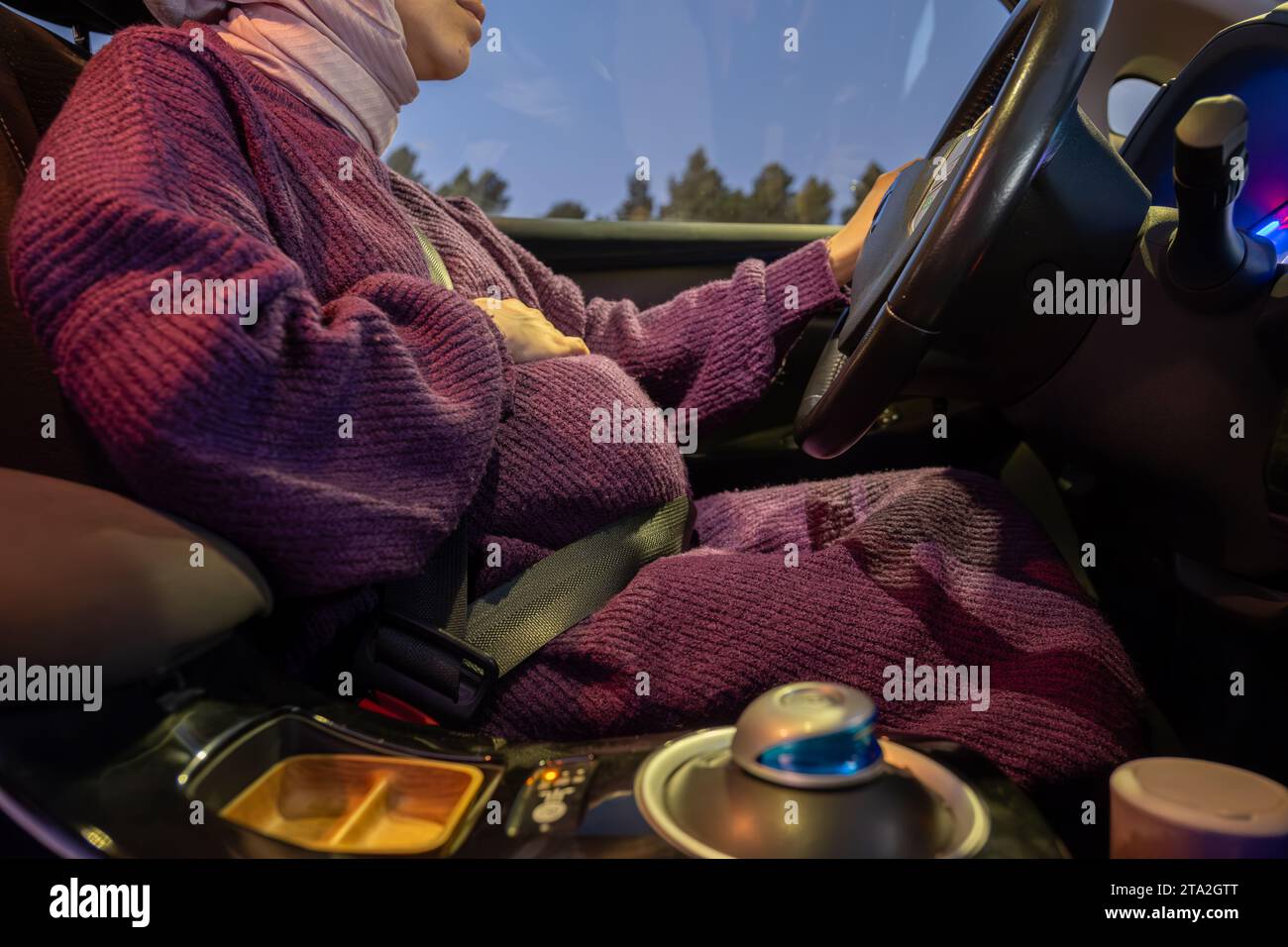 Eine schwangere Frau, die einen Sicherheitsgurt trägt, fährt ein Auto.  Sicherheit und Fahrverhalten während der Schwangerschaft, auf Reisen  Stockfotografie - Alamy