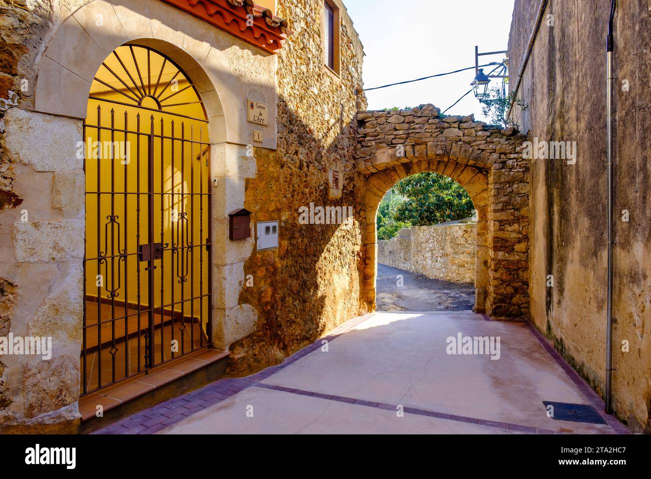 Leere Straße und Portal, mittelalterliche Stadt Regencós, Baix Empordà, Lower Empordà comarca, Provinz Girona, Katalonien, Spanien Stockfoto