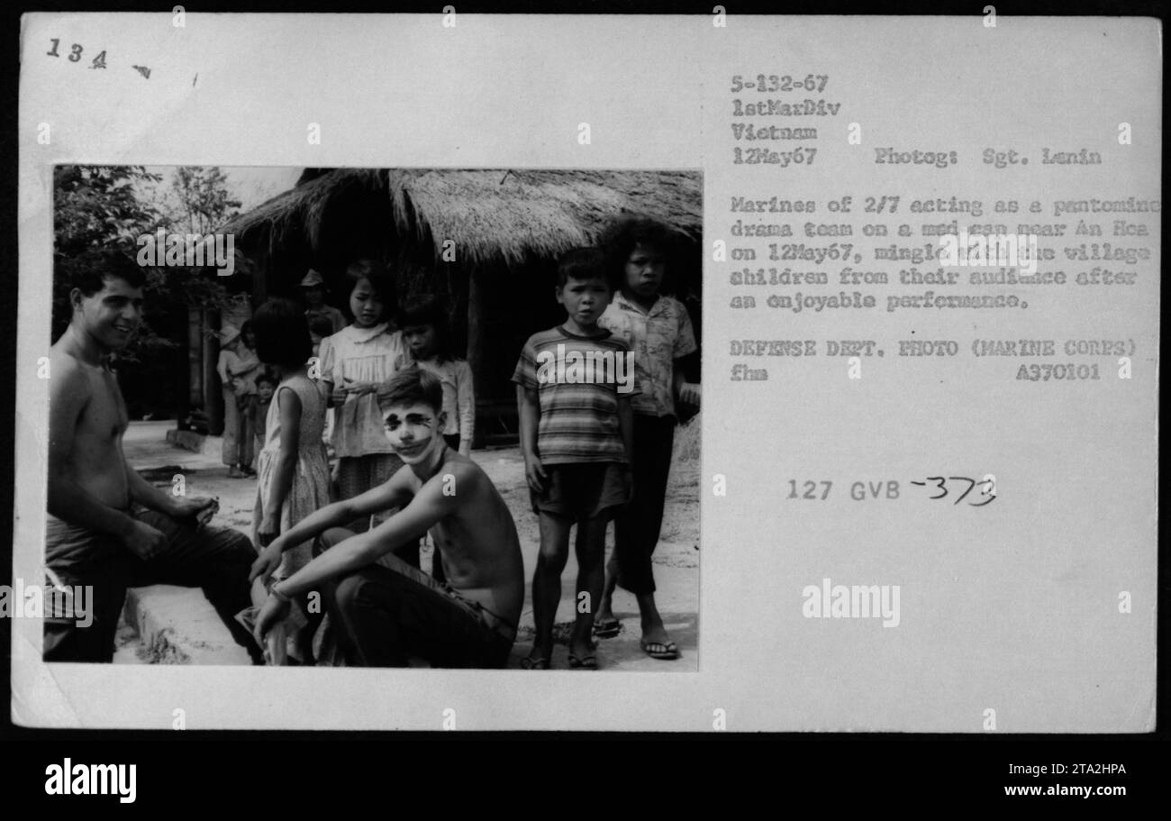 Marines aus dem 2. Bataillon, 7. Marines werden mit vietnamesischen Dorfkindern interagiert, nachdem sie am 12. Mai 1967 in einem komödiantischen Stück in der Nähe von an Hoa aufgetreten waren. Das Foto zeigt einen Moment der Kameradschaft zwischen den amerikanischen Soldaten und der lokalen Gemeinschaft. Stockfoto