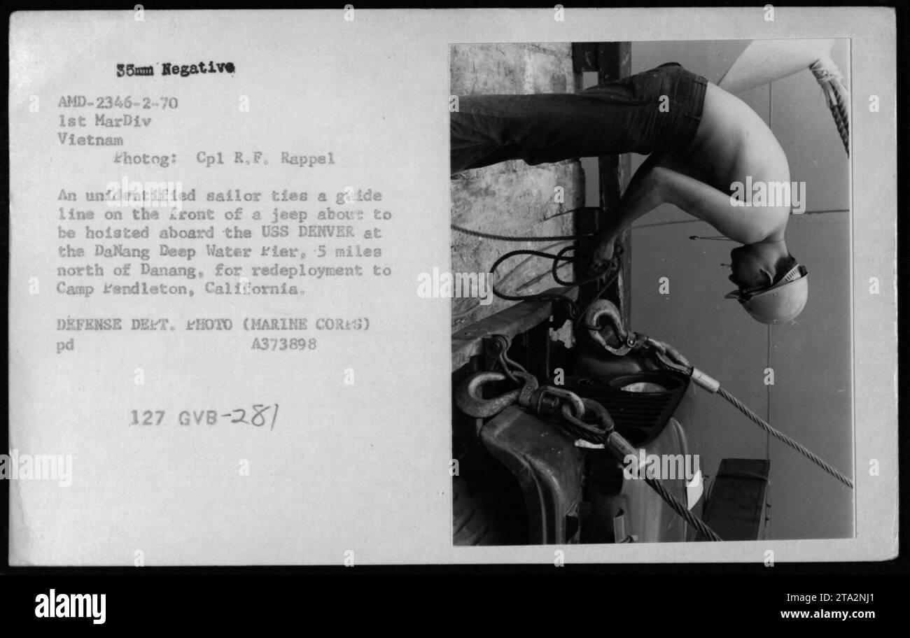 Ein nicht identifizierter Seemann bindet eine Führungslinie an der Vorderseite eines Jeeps an, bevor er an Bord der USS DENVER am Danang Deep Water River nördlich von Danang gehoben wird. Der Jeep wird für den Umzug nach Camp Pendleton, Kalifornien, vorbereitet. Foto: CPL R. F. Rappel, 1. MarDiv Vietnam. Stockfoto