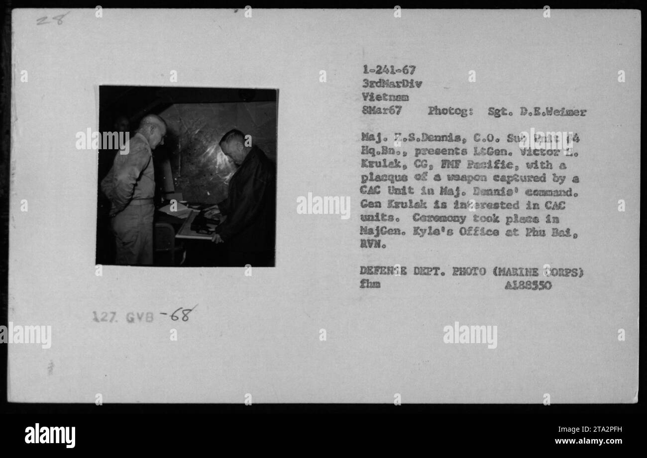 Bildunterschrift: „LtGen. Victor H. Krulek, CG, FMF Pacific, erhält während einer Zeremonie in Najcen eine Gedenktafel mit einer gefangenen Waffe von Major H.S. Dennis, C.O. Untereinheit 4 HQ.bn. Die Waffe wurde von einer CAC-Einheit unter Major Dennis Befehl gefangen genommen. Foto, aufgenommen am 8. März 1967 in Najcen, Vietnam von Sgt. D.E. Helmer." Stockfoto
