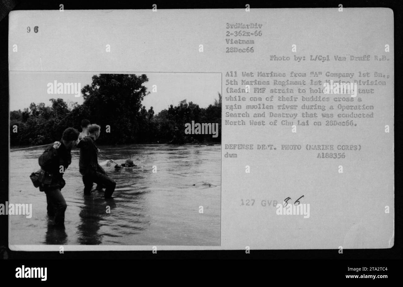 Marines der A-Kompanie, 1. Bataillon, 5. Marines-Regiment, 1. Marine-Division, wurden am 28. Dezember 1966 während einer Such- und Zerstörungsoperation nordwestlich von Chu Lai, Vietnam, fotografiert. Das Foto zeigt die Marines, die mit Hilfe ihrer Kameraden einen regengeschwollenen Fluss überqueren, während sie sich anstrengen, um eine straffe Linie zu halten. Stockfoto