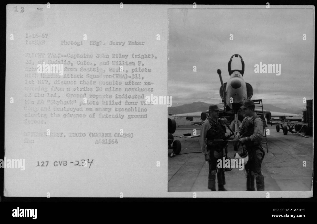 Die Marinekapitäne John Riley und William F. Schusb, Piloten der Marine Attack Squadron (VMA)-311, 1. MA, diskutieren ihre Missionsergebnisse, nachdem sie am 16. Januar 1967 von einem Angriff 30 Meilen nordwestlich von Chu Lai in Vietnam zurückgekehrt waren. Bodenberichte zeigten, dass sie erfolgreich vier Viet Cong getötet und eine feindliche Struktur zerstört hatten, was den freundschaftlichen Bodenstreitkräften zugute kam. Stockfoto