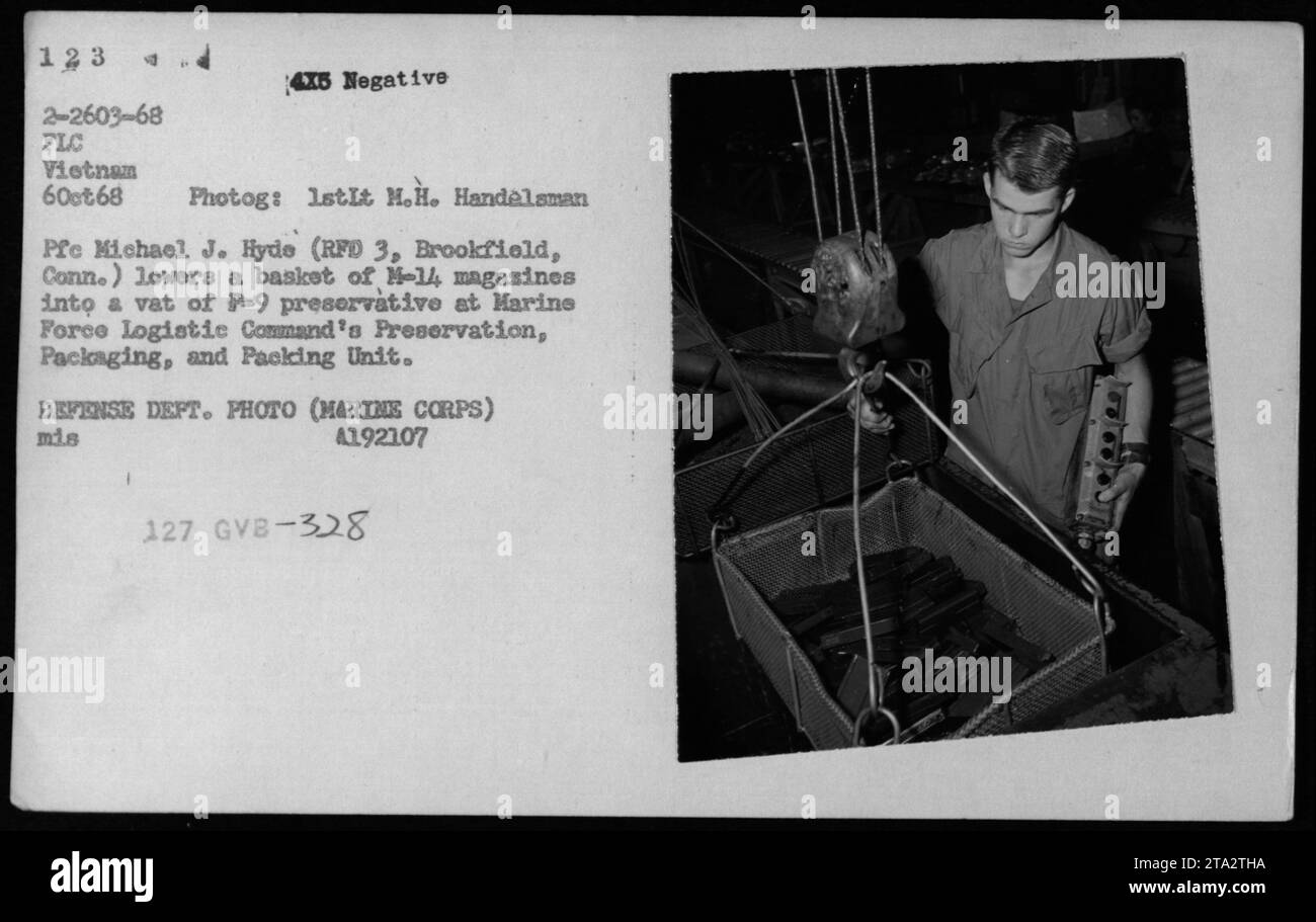 Soldat Michael J. Hyde (RFD 3, Brookfield, Conn.) ist hier zu sehen, wie er am 6. Oktober 1968 einen Korb mit N-14-Magazinen in einen behälter mit P-9-Konservierungsmitteln bei der Preservation, Packaging and Packaging Unit des Marine Force Logistic Command in Vietnam senkte. Dieses Bild zeigt die Lade- und Entladeaktivitäten der Vorräte während des Vietnamkriegs. Stockfoto