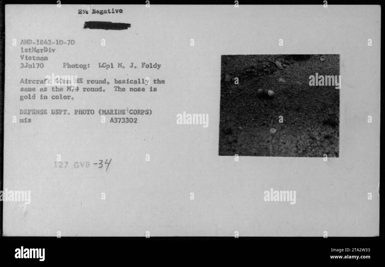 Die Mitarbeiter des Marine Corps werden am 3. Juli 1970 in Vietnam gezeigt, wie sie eine 40mm High explosive (HE) Runde für Flugzeuggewehre handhaben. Die runde, ähnlich wie die M79-Runde, hat eine goldfarbene Nase. Dieses Bild wurde von LCpl M. J. Foldy aufgenommen und stammt aus der Fotosammlung des Verteidigungsministeriums. Stockfoto