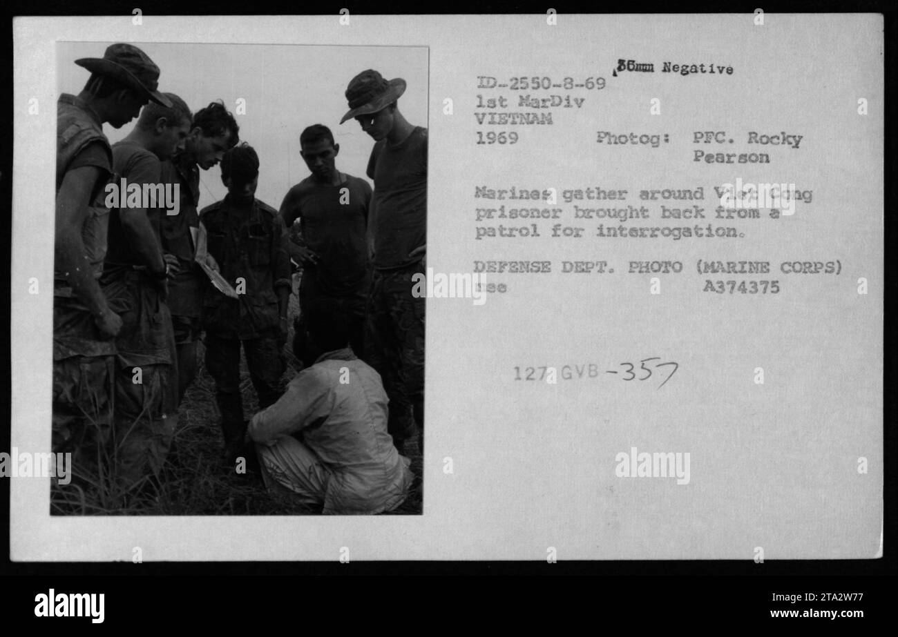 Marines der 1. Marine-Division in Vietnam, 1969, werden in der Nähe eines Gefangenen aus Vietnam gesehen, der während einer Patrouille festgenommen wurde. Die Marines umkreisen den Verdächtigen und bereiten sich darauf vor, ihn zum Verhör aufzunehmen. Dieses Bild zeigt die militärischen Aktivitäten und Verfahren, die zur Identifizierung und Befragung von Gefangenen vietnamesischen Mitgliedern während des Vietnamkriegs befolgt wurden. Stockfoto
