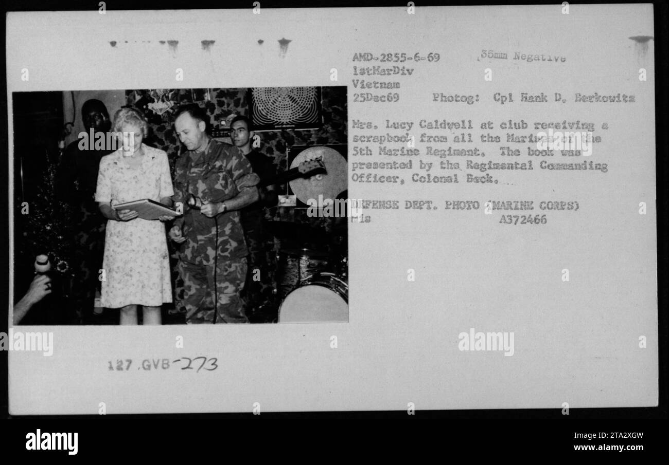 Marines im Sth Marine Regiment präsentieren MES ein Sammelalbum. Lucy Caldvell im Club in Vietnam. Das Buch wurde vom Regimental Commanding Officer Colonal am 25. Dezember 1969 überreicht, wie es von CPL Hank D. Berkowitz vom Verteidigungsministerium (Marine Corps) gefangen genommen wurde. Stockfoto
