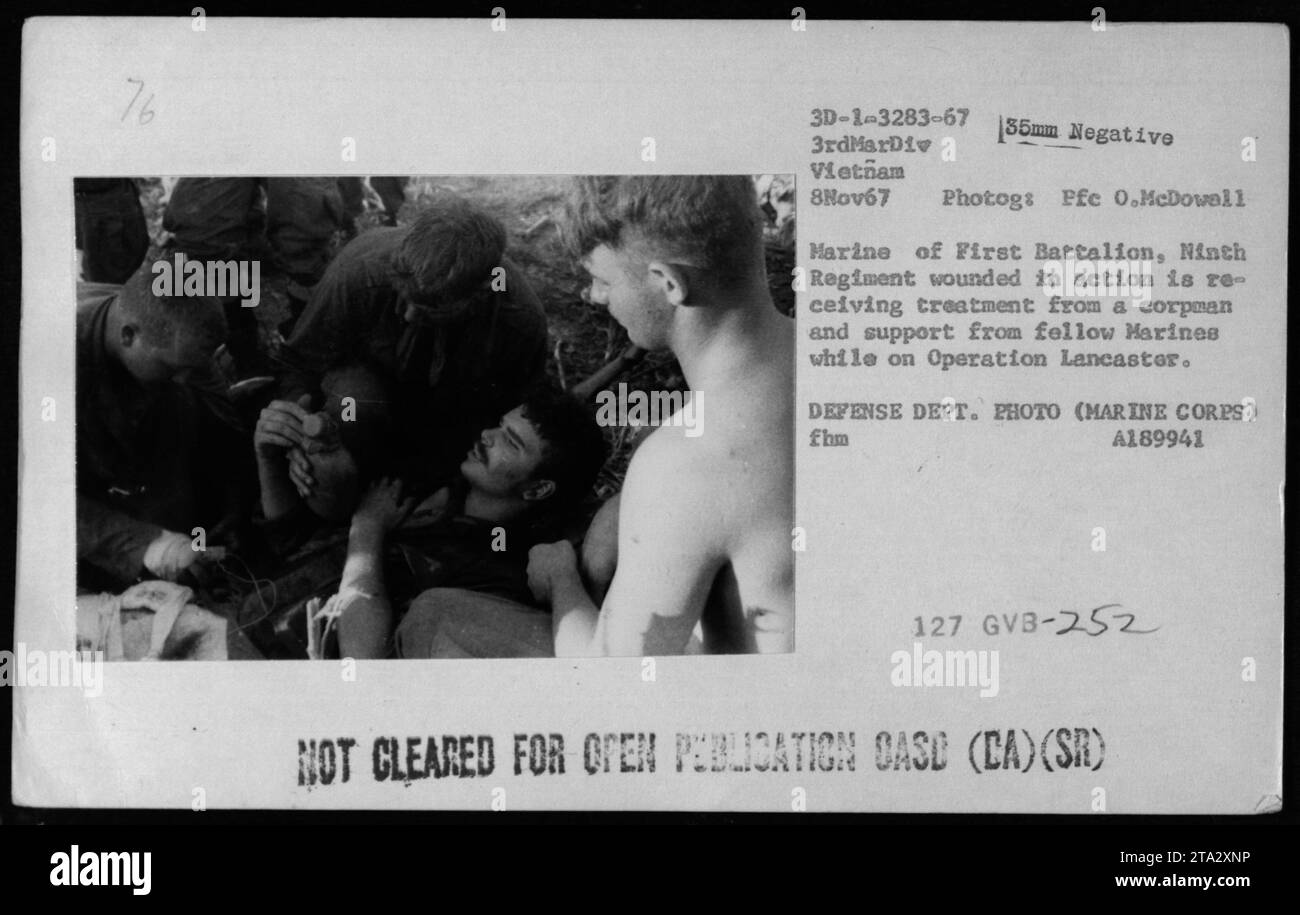 Am 8. November 1967 wird ein verwundeter Marine während der Operation Lancaster von einem Korpsmann behandelt und von Marinekollegen in Vietnam unterstützt, fotografiert von PFC O. McDowell. Stockfoto