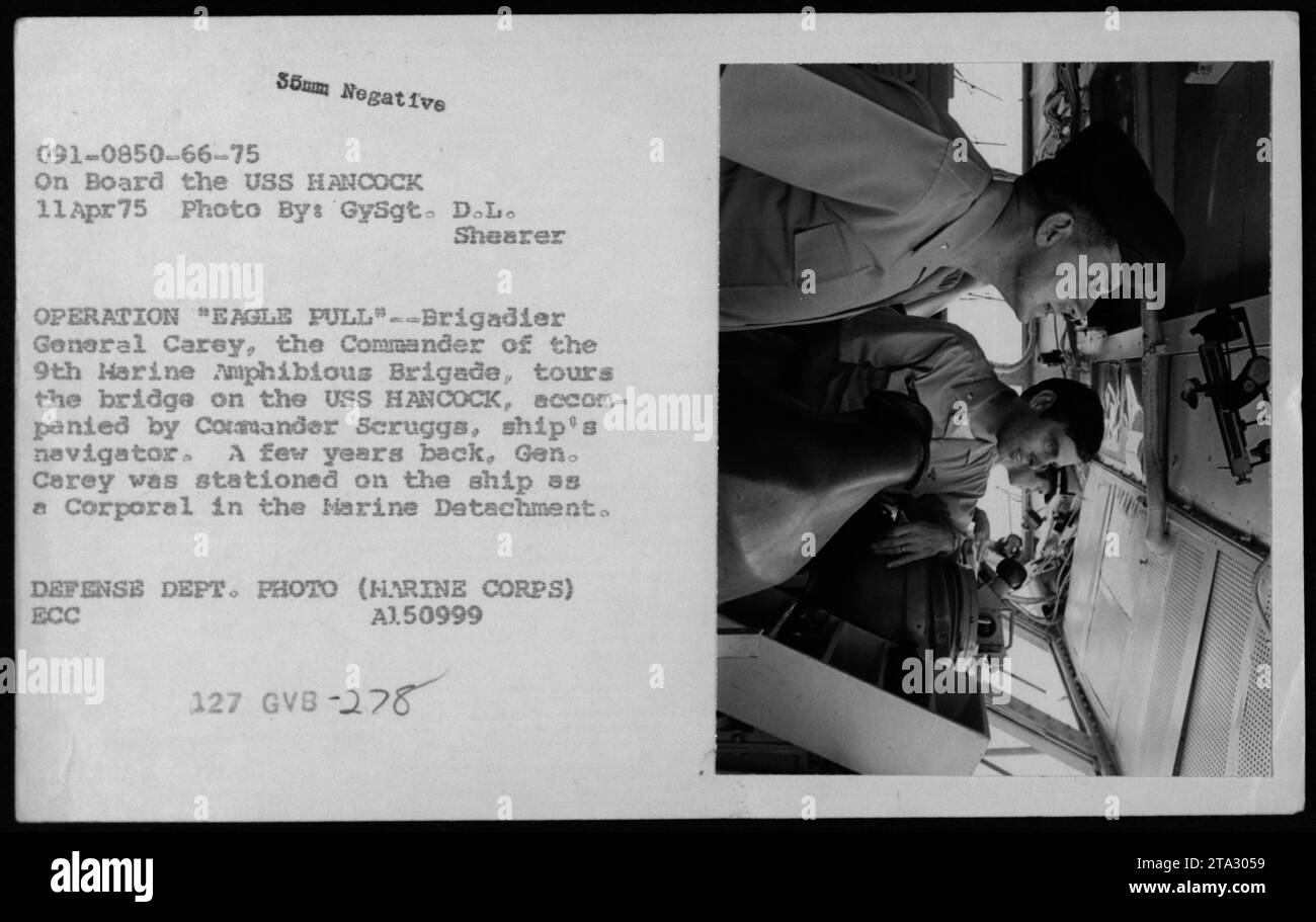 Brigadegeneral Carey, Kommandeur der 9. Marine Amphibious Brigade, besichtigt die Brücke der USS HANCOCK während der Operation Eagle Pull am 11. April 1975. Er wird von Commander Scruggs, dem Navigator des Schiffes, begleitet. General Carey war zuvor auf der USS HANCOCK als Korporal im Marine Detachment gedient. Stockfoto