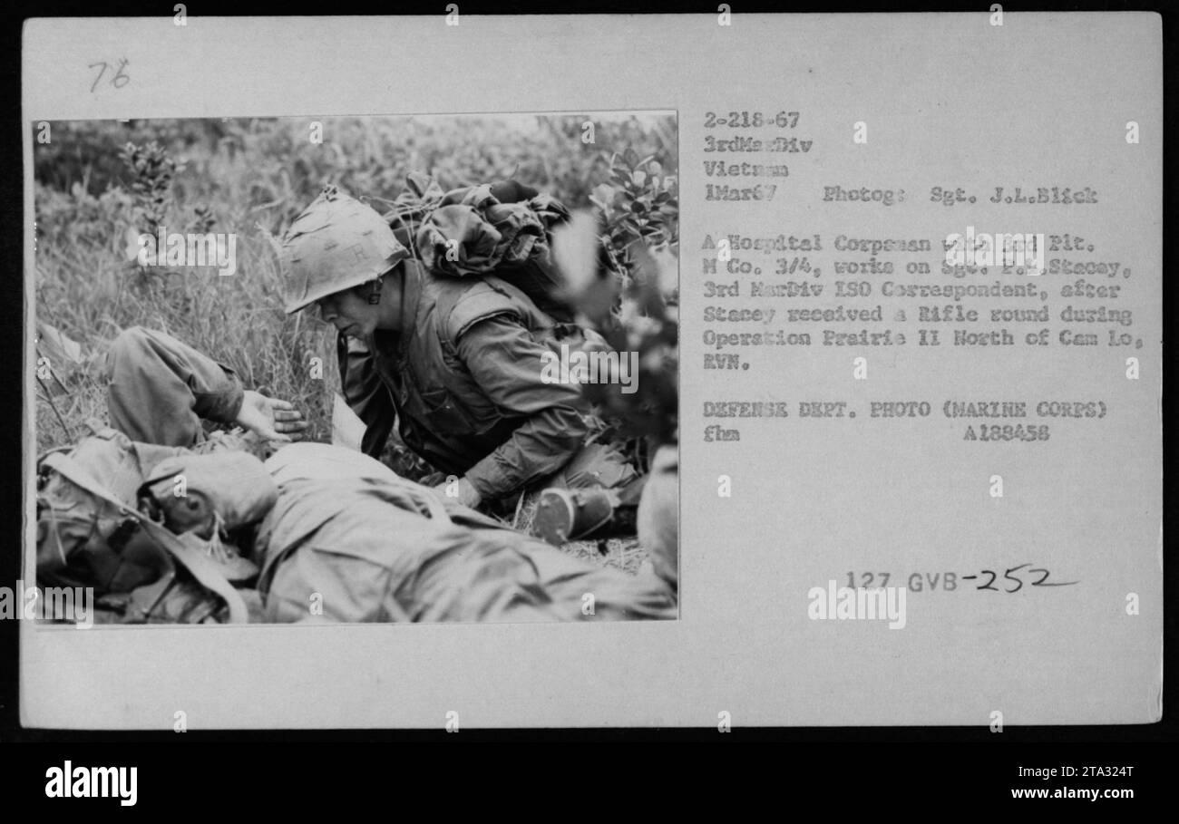 Mitarbeiter des US Marine Corps behandeln Sgt. P.L. Stacey, einen 3. MarDiv ISO Korrespondenten, nachdem er während der Operation Prairie II in Vietnam von einem Gewehr verwundet wurde. Das Foto zeigt einen Sanitäter vom 3. Zug der H-Kompanie 3/4, der medizinische Hilfe anwendet. Dieses Bild ist vom 1. März 1967. Stockfoto