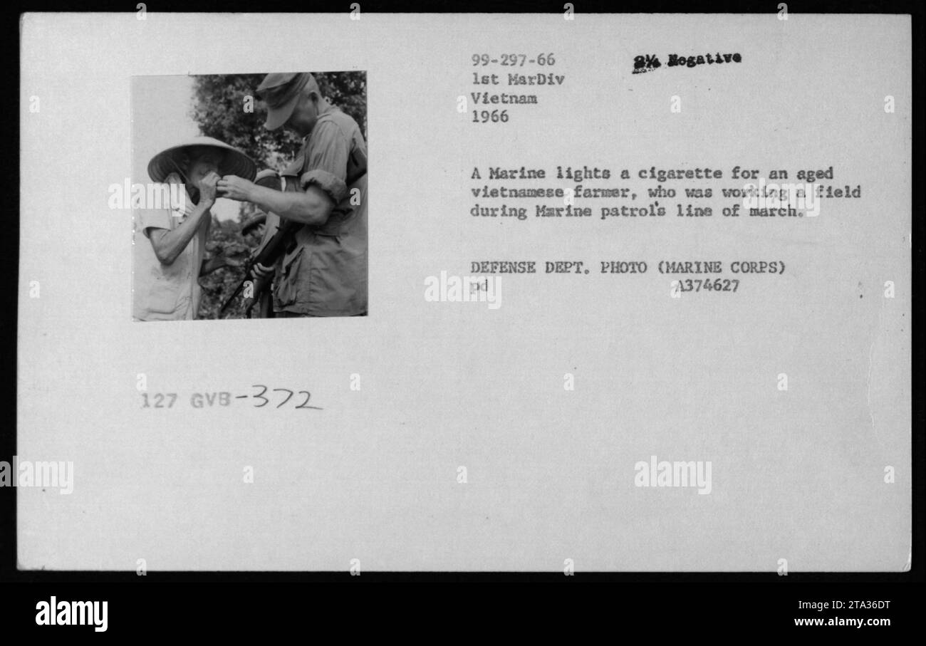 Ein US-Marine hilft einem älteren vietnamesischen Bauern, indem er eine Zigarette während einer Patrouille 1966 anzündet. Das Bild zeigt einen Moment der Interaktion zwischen amerikanischem Militär und Zivilisten während des Vietnamkriegs. Dieses Foto wurde vom Verteidigungsministerium (Marine Corps) aufgenommen. Stockfoto