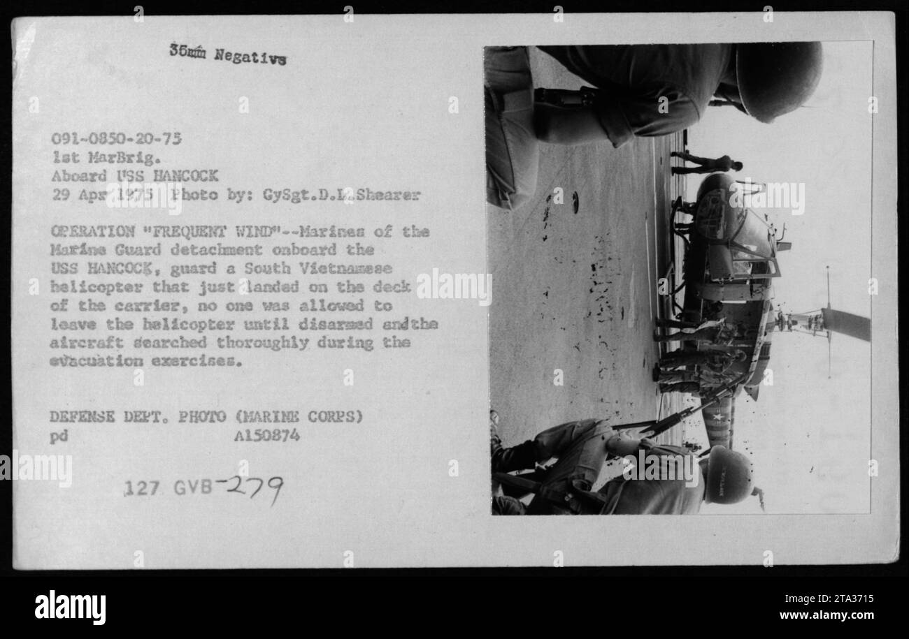 Marines aus der Marine Guard-Abteilung an Bord der USS HANCOCK schützen einen südvietnamesischen Hubschrauber, der während der Operation häufige Windevakuierungsübungen im April 1975 landete. Stockfoto