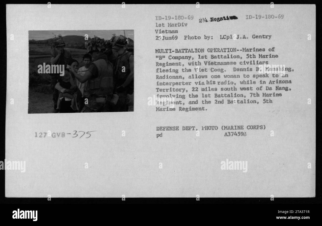 Am 29. Juni 1969 unterstützten Marines der B Company, 1st Battalion, 5th Marine Regiment vietnamesische Zivilisten, die auf der Flucht der vietnamesischen Truppen im Arizona-Territorium, 22 Meilen südwestlich von da Nang, waren, wobei der Radioman Dennis B. Menshing einer Frau erlaubte, während einer Operation mit mehreren Bataillonen mit einem Dolmetscher zu sprechen. Stockfoto