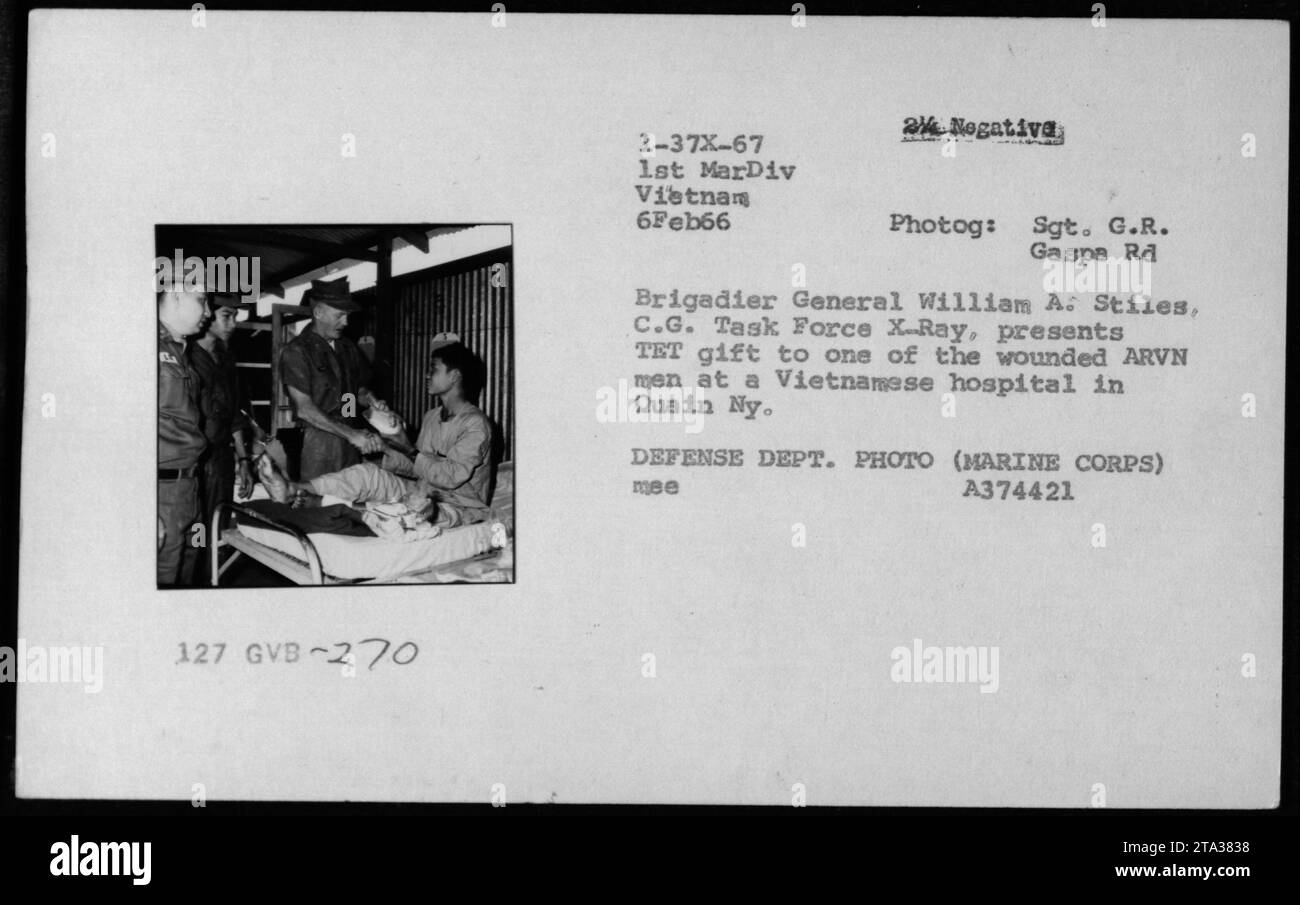 Brigadegeneral William A. Stiles, C.G. Task Force X-Ray, überreicht ein TET-Geschenk an einen verwundeten ARVN-Mann in einem vietnamesischen Krankenhaus in Quain NY. Das Foto wurde am 6. Februar 1966 während des Vietnamkrieges aufgenommen. Stockfoto