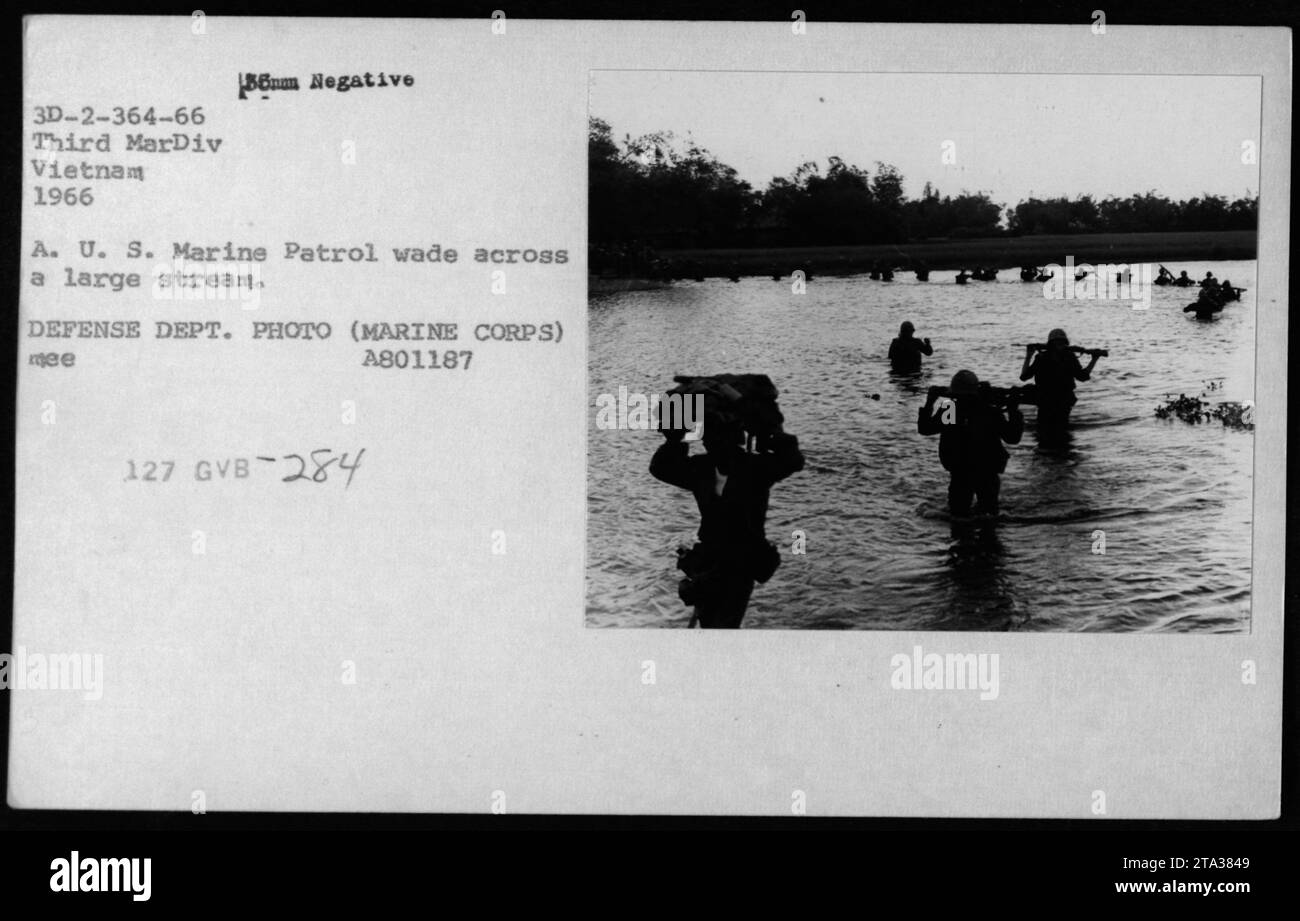 Eine Gruppe von Soldaten der US-Marine kann 1966 über einen großen Fluss in Vietnam waten. Dieses Foto zeigt eine Routinepatrouille, die von der Dritten Marine-Division während des Vietnamkriegs durchgeführt wurde. VERTEIDIGUNGSABTEILUNG. FOTO (MARINE CORPS) A801187 ME 127 GVB 284. Stockfoto