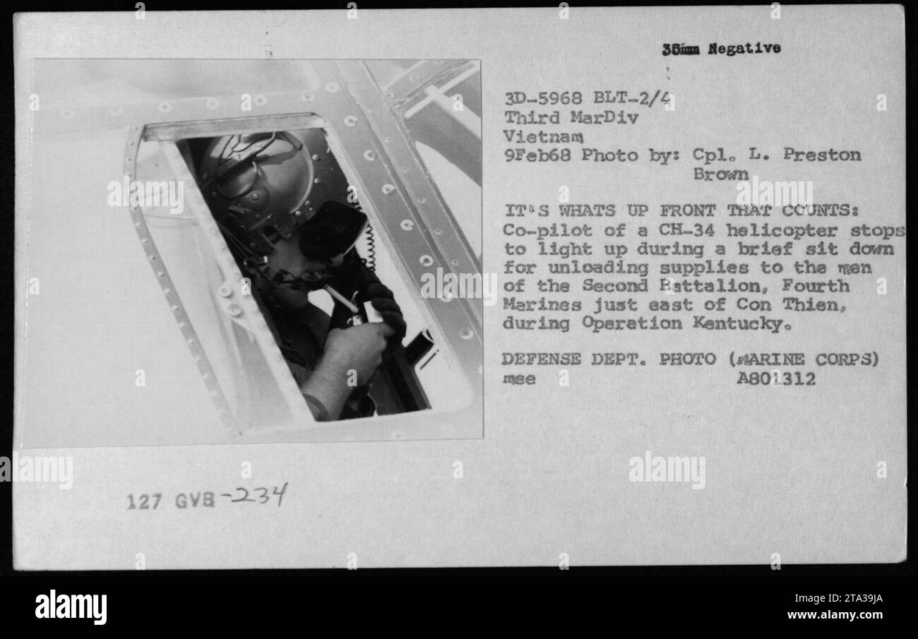 Gregory 'Pappy' Boyington besucht sein altes Geschwader am 9. Februar 1968. Das Foto zeigt Einzelpersonen und Gruppen, einschließlich Piloten und Besatzungsmitgliedern. Das Bild fängt einen Moment ein, in dem ein CH-34-Hubschrauber-Co-Pilot eine Pause einlegt, um beim Entladen der Vorräte für das zweite Bataillon, die Vierten Marines, während der Operation Kentucky, einen Rauch zu nehmen. Das Foto wurde von CPL L. Preston Brown aufgenommen und ist ein Foto des Verteidigungsministeriums vom Marine Corps. Die spezifische negative Zahl ist 3D-5968 und die erwähnte Einheit ist GVB-234 36 von BLT-2/4 drittes MarDiv Vietnam. Stockfoto
