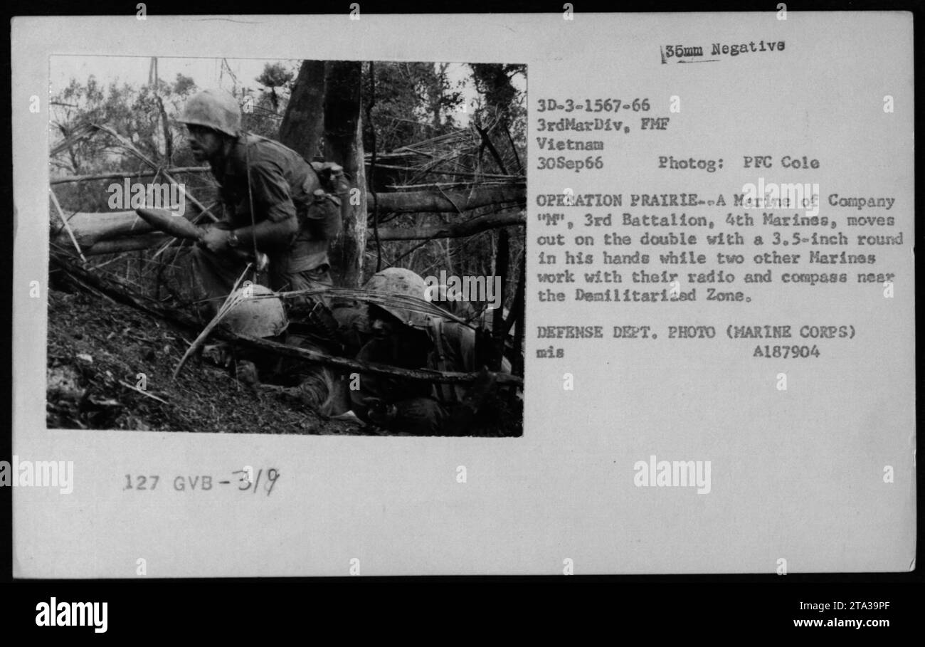 Ein Marine der Kompanie M, 3. Bataillon, 4. Marines, mit einer 3,5-Zoll-Runde, während zwei weitere Marines während der Operation PRAIRIE in Vietnam am 30. September 1966 ein Radio und einen Kompass in der Nähe der entmilitarisierten Zone verwenden. Dieses Bild zeigt den Einsatz von Raketenwerfern durch amerikanisches Militär während des Vietnamkriegs. VERTEIDIGUNGSABTEILUNG. FOTO (MARINE CORPS) MIS A187904. Stockfoto