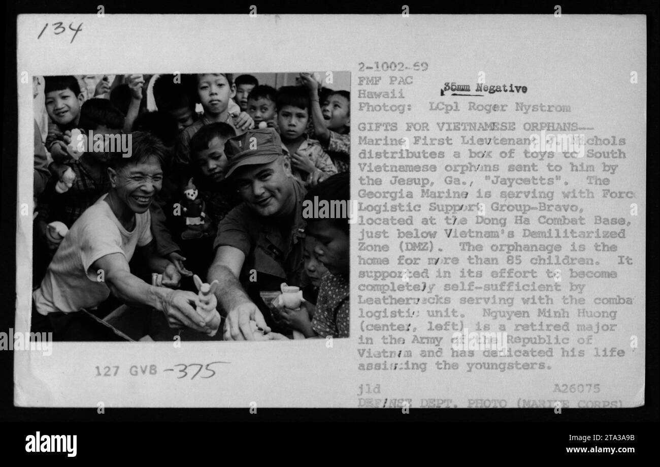 Marine First Lieutenant J. Nichols verteilt Spielzeug an südvietnamesische Waisenkinder in einem Waisenhaus in der Nähe der Demilitarisierten Zone (DMZ). Die Spielzeuge wurden von der Organisation Jaycetts aus Jesup, Georgia, geschickt. Das Waisenhaus, unterstützt von Leathernecks von der Forth Logistic Support Group-Bravo, beherbergt über 85 Kinder. Nguyen Minh Huong, ein pensionierter Major in der Armee der Republik Vietnam, widmet sich der Unterstützung der Kinder. Stockfoto