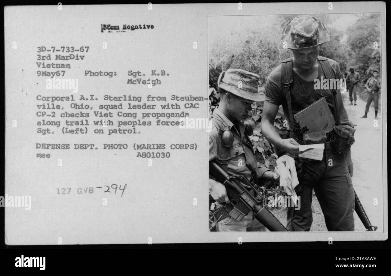 Korporal A.I. Sterling aus Steubenville, Ohio, ein Truppenführer mit CAC CP-2, überprüft Viet Cong-Propaganda auf einer Spur mit People's Forces Sergeant (links) während einer Patrouille in Vietnam am 9. Mai 1967. Dieses Bild ist ein Foto der Verteidigungsabteilung (Marine Corps) mit der Seriennummer A801030 und der Referenznummer GVB-294. Stockfoto