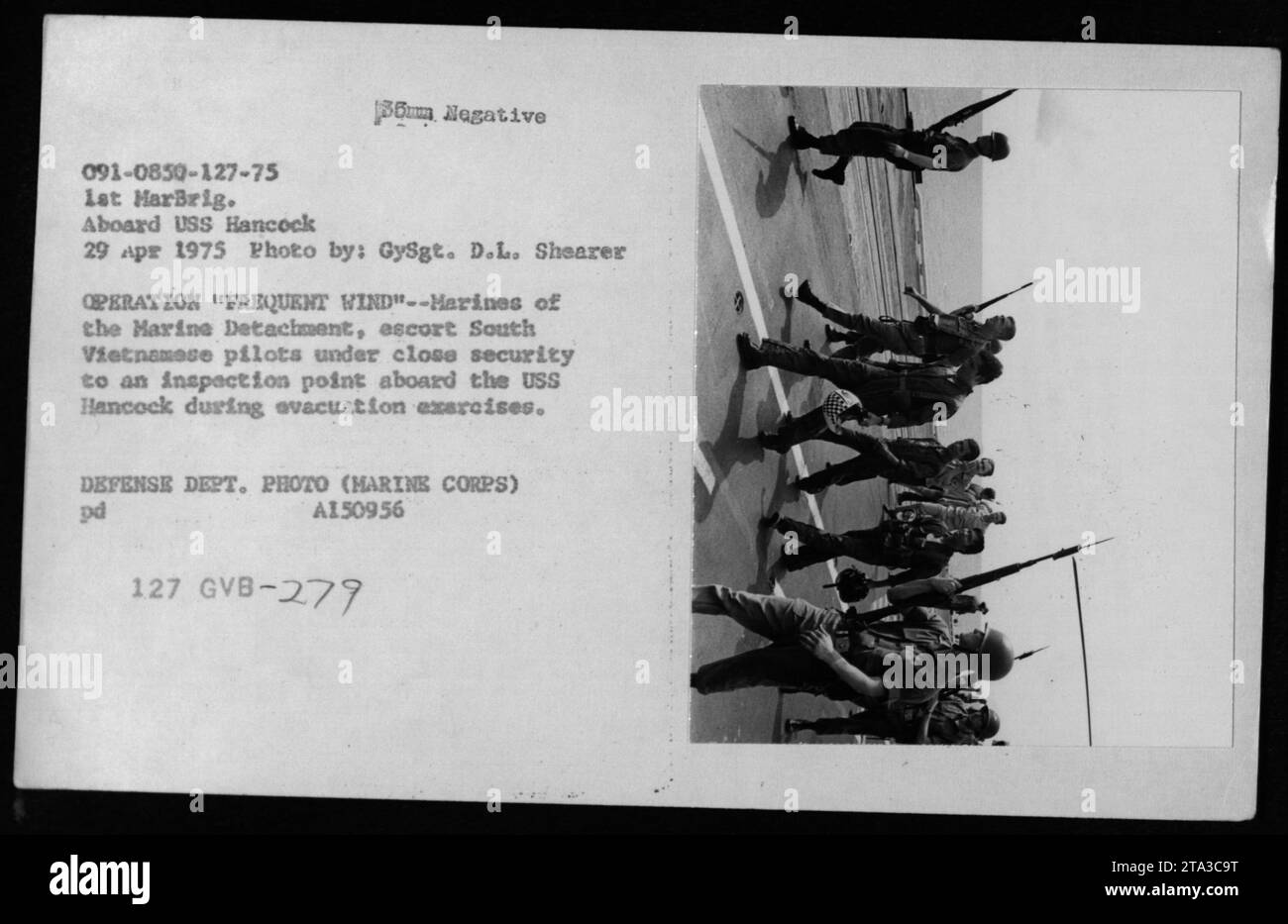 Das Personal des Marine Detachment eskortiert südvietnamesische Piloten zu einem Inspektionspunkt auf der USS Hancock am 29. April 1975, wo Evakuierungsübungen der Operation Frequent Wind durchgeführt werden. Stockfoto