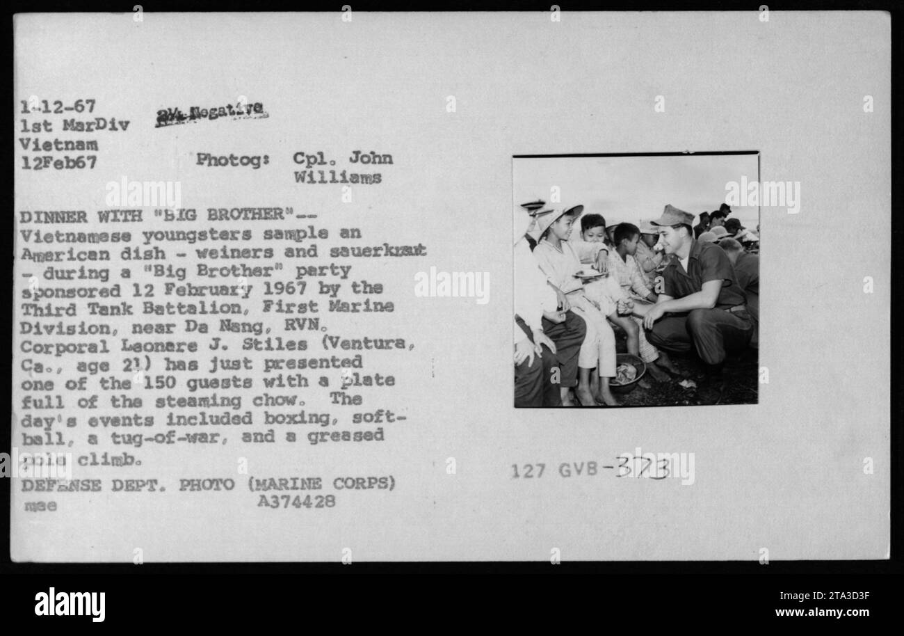 Vietnamesische Jugendliche nehmen am 12. Februar 1967 an einer Big Brother Party Teil, die vom Dritten Panzerbataillon der First Marine Division in der Nähe von da Nang, RVN, gesponsert wurde. Corporal Leonere J. Stiles präsentiert einem der 150 Gäste einen Teller mit Weiners und Sauerkraut. Die Veranstaltung beinhaltete auch Boxen, Softball, ein Tauziehen und einen gefetteten Polenklimmen. Stockfoto