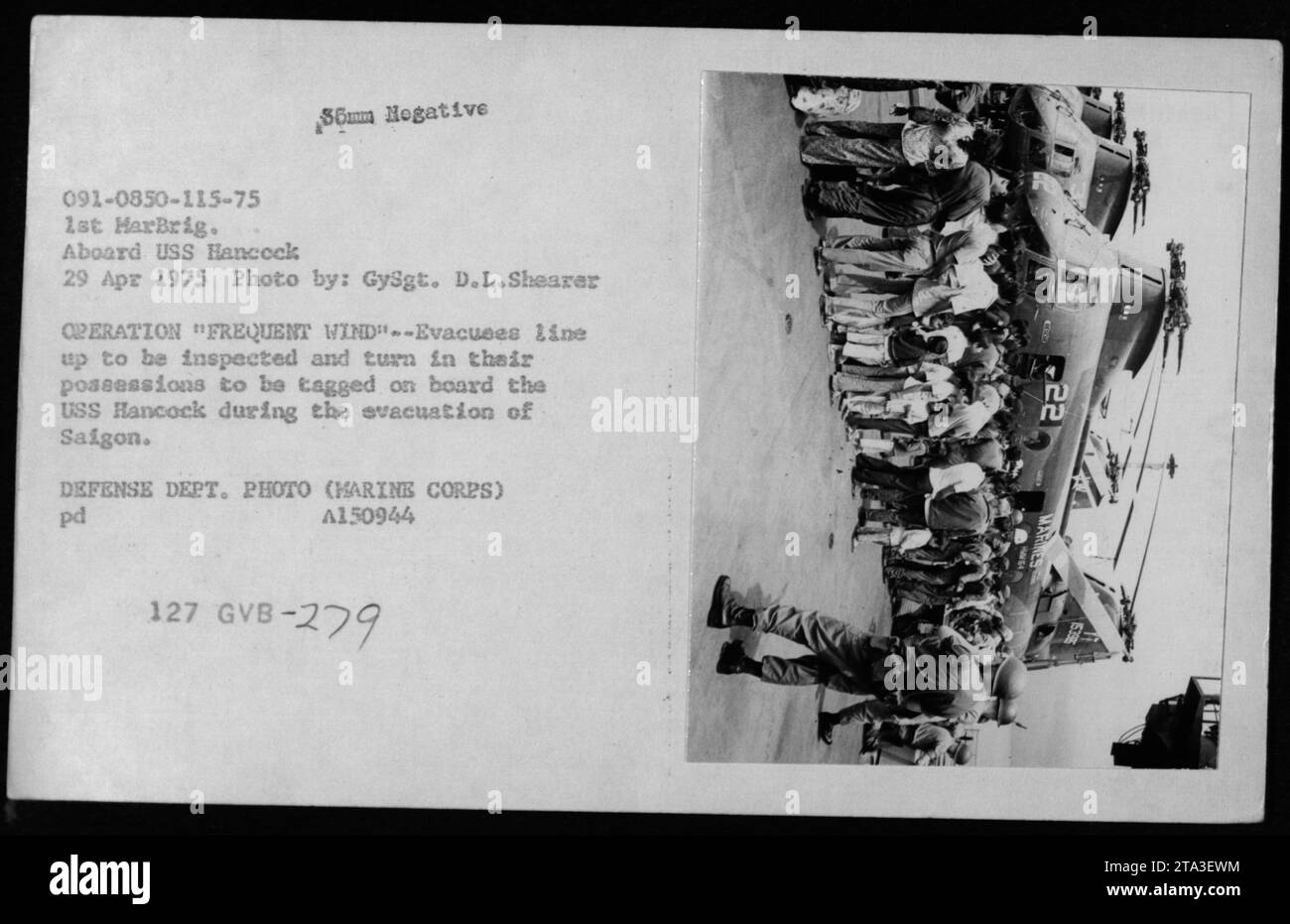 Soldaten stellen sich auf, um inspiziert zu werden und übergeben ihre Sachen, um an Bord der USS Hancock während der Evakuierung von Saigon markiert zu werden. Dieses Foto wurde während der Operation Frequent Wind, der Evakuierung von Phnom Penh und Saigon im Jahr 1975 aufgenommen. Stockfoto