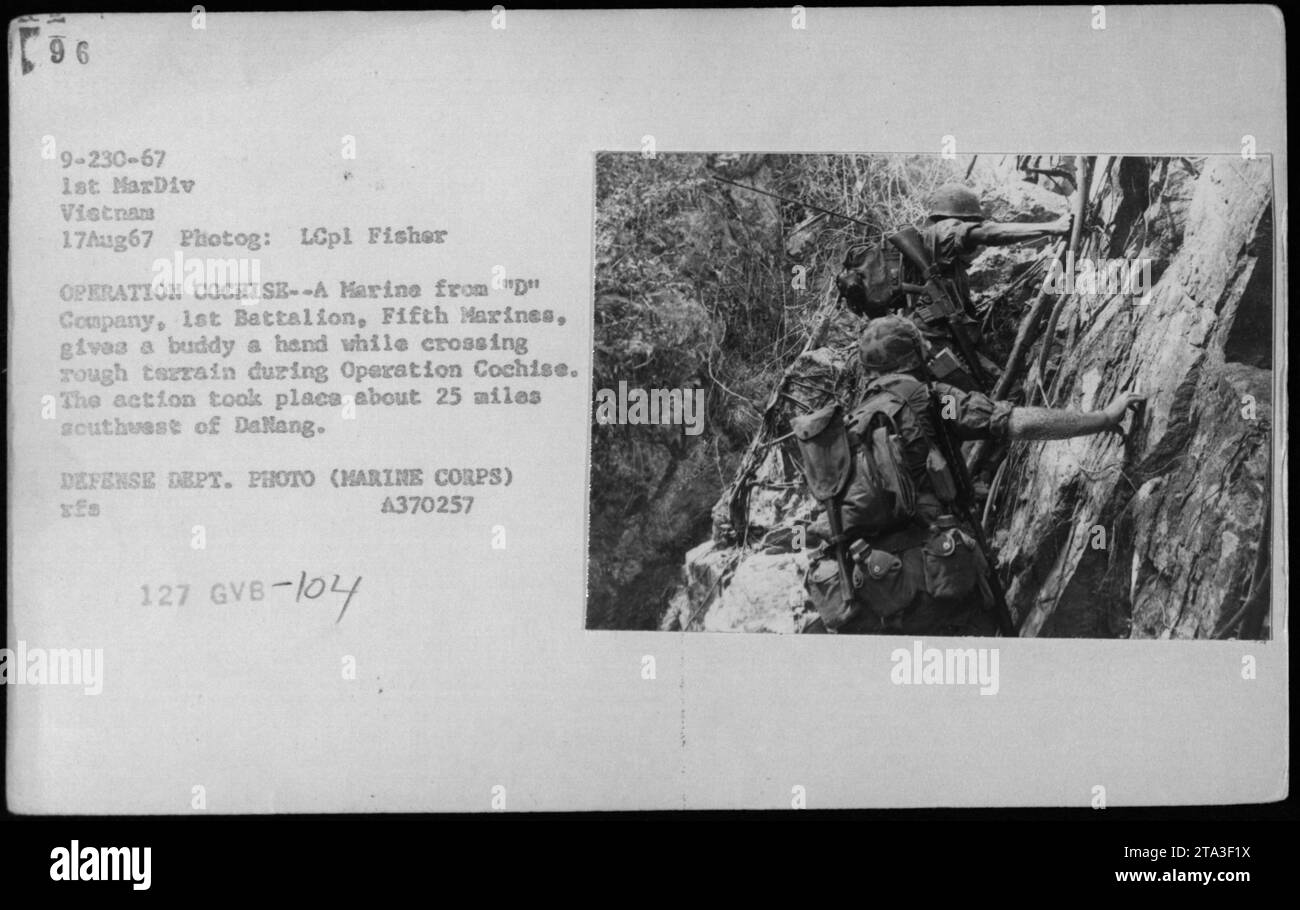 Ein Marine der 'D' Kompanie, 1. Bataillon, 5. Marines, der einem anderen Marine bei der Navigation in schwierigem Gelände während der Operation Cochise, die etwa 25 Meilen südwestlich von Danang durchgeführt wurde, Hilfe leistet. Dieses Foto wurde von LCpl Fisher am 17. August 1967 aufgenommen. Es ist ein offizielles Foto des Verteidigungsministeriums (Marine Corps) mit der Aktenzeichen A370257 127 GVB-104. Stockfoto