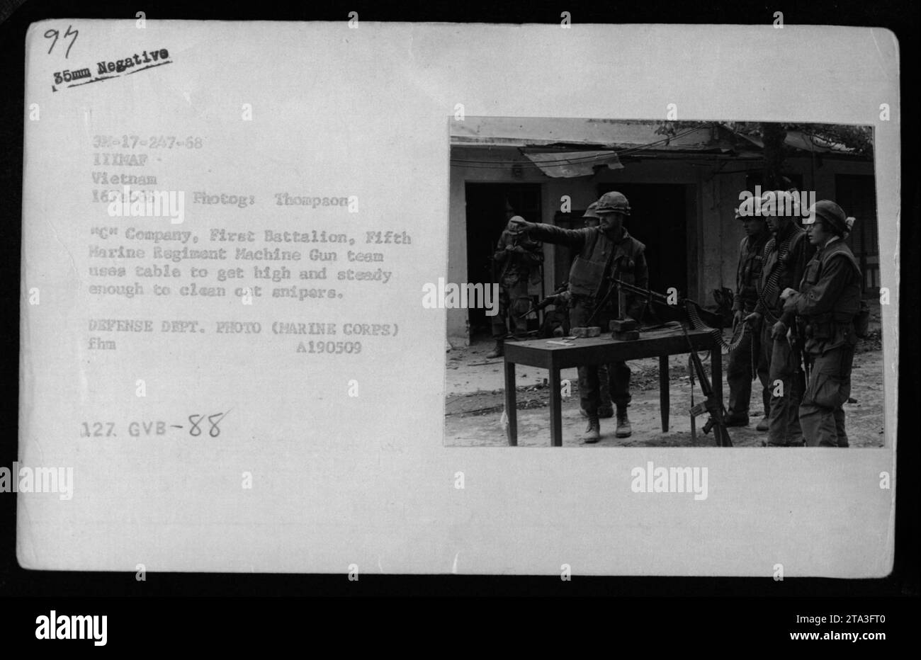 Marines der C-Kompanie, First Battalion, Fifth Marine Regiment nutzen einen Tisch, um sich zu erheben und eine stabile Position zu halten, während sie während des Kampfes in Vietnam am 16. Februar 1968 feindliche Scharfschützen angreifen. Dieses Foto wurde von Photogs Thompson aufgenommen und ist ein offizielles Foto des Verteidigungsministeriums. Stockfoto