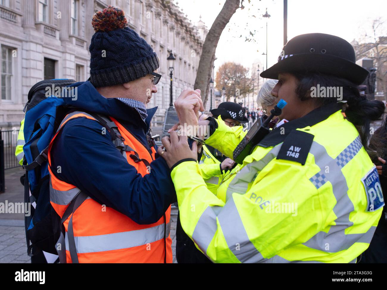 Whitehall, London, Großbritannien. November 2023. Just Stop Oil Demonstranten protestierten heute wieder in London. Sie begannen ihren Protest am Trafalgar Square. Als zwei ältere Demonstranten außerhalb der Downing Street auf die Straße marschierten, wurden sie schnell von der Met Police verhaftet und mit Handschellen gefesselt. Julie Redman, 72, die heute verhaftet wurde, ist eine Großmutter von sieben Kindern aus Fife. Sie sagte: „Ich bin verzweifelt wegen der Klimakrise. Sie beschleunigt sich in alarmierendem Tempo, und dennoch erteilt unsere Regierung immer noch neue Lizenzen für Öl und Gas. Es sind meine Enkel, die die Hauptlast des Klimazusammenbruchs tragen werden Stockfoto
