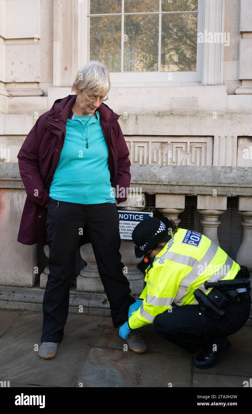 Whitehall, London, Großbritannien. November 2023. Just Stop Oil Demonstranten protestierten heute wieder in London. Sie begannen ihren Protest am Trafalgar Square. Als zwei ältere Demonstranten außerhalb der Downing Street auf die Straße marschierten, wurden sie schnell von der Met Police verhaftet und mit Handschellen gefesselt. Julie Redman, 72, (im Bild), die heute verhaftet wurde, ist eine Großmutter von sieben Kindern aus Fife. Sie sagte: „Ich bin verzweifelt wegen der Klimakrise. Sie beschleunigt sich in alarmierendem Tempo, und dennoch erteilt unsere Regierung immer noch neue Lizenzen für Öl und Gas. Es sind meine Enkel, die die Hauptlast des Klimas tragen werden Stockfoto