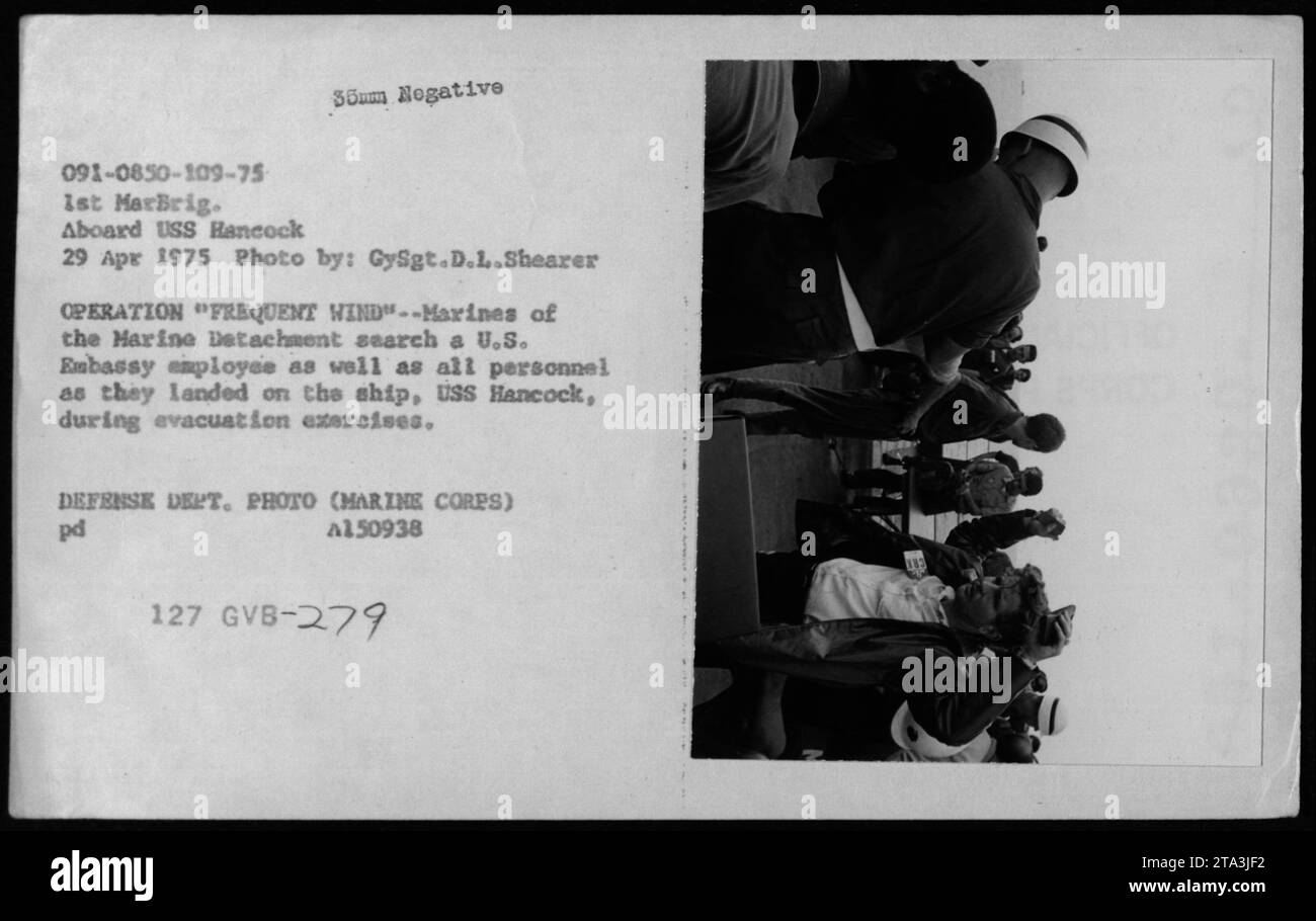 US-Marines durchsuchten und inspizierten Personal, einschließlich eines Mitarbeiters der US-Botschaft, nach ihrer Ankunft an Bord der USS Hancock während der Evakuierungsübungen der Operation Frequent Wind, 29. April 1975. Dieses Foto zeigt die akribischen Sicherheitsmaßnahmen während des Vietnamkriegs. Stockfoto