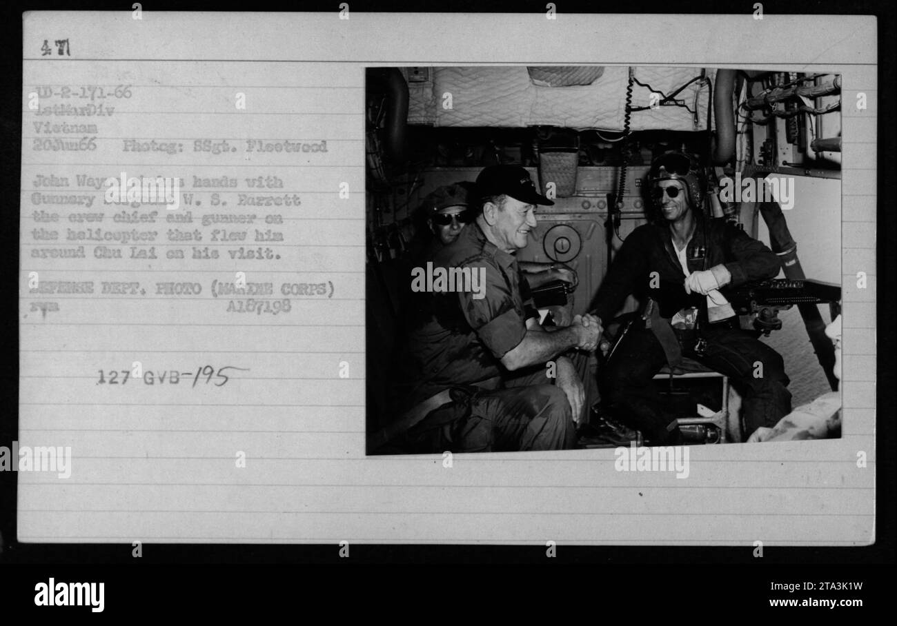 Schauspieler John Wayne schüttelt am 20. Juni 1966 in Vietnam die Hand mit Gunnery Sergeant W. S. Barrett. Wayne besuchte Chu Lai und wurde in einem Helikopter namens Gunner-08 geflogen. Dieses Foto wurde von einem Fotografen des Verteidigungsministeriums aufgenommen und ist Teil der Sammlung, die die militärischen Aktivitäten der USA während des Vietnamkriegs dokumentiert. Stockfoto