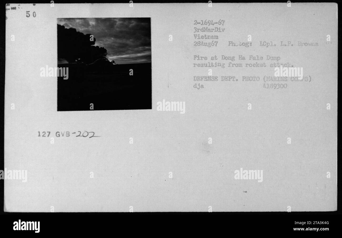 Feuer und Explosionen ereignen sich am 28. August 1967 auf der Dong Ha Fuel Dump in Vietnam nach einem Raketenangriff. Während die Marines reagieren, steigt Rauch aus dem beschädigten Standort. Stockfoto
