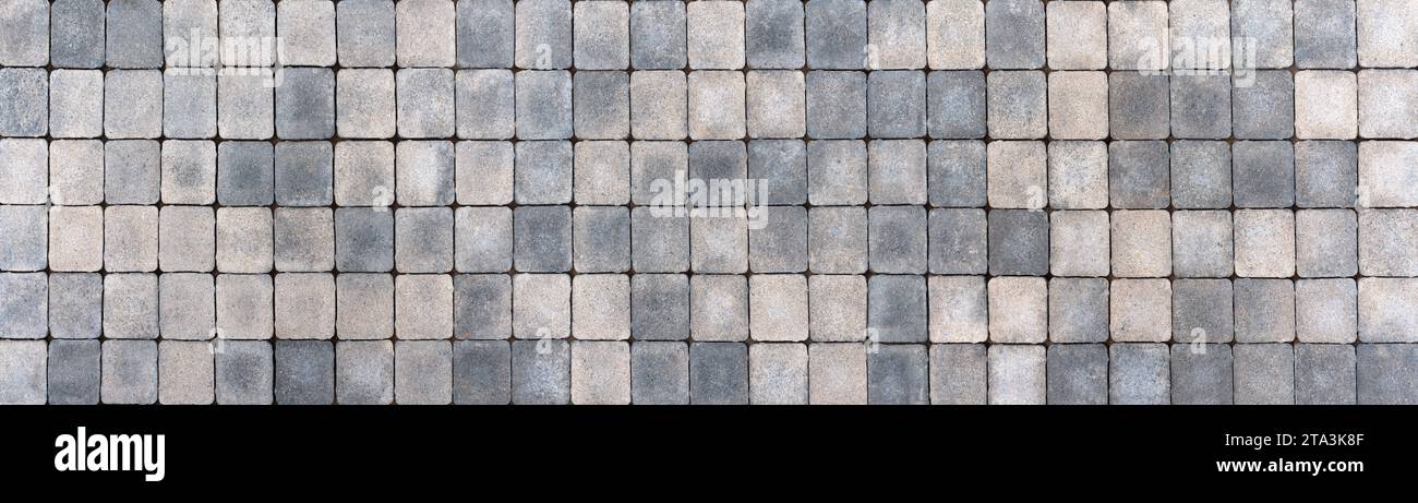 Bürgersteig aus quadratischen Pflastersteinen in verschiedenen beigen und grauen Farben Stockfoto