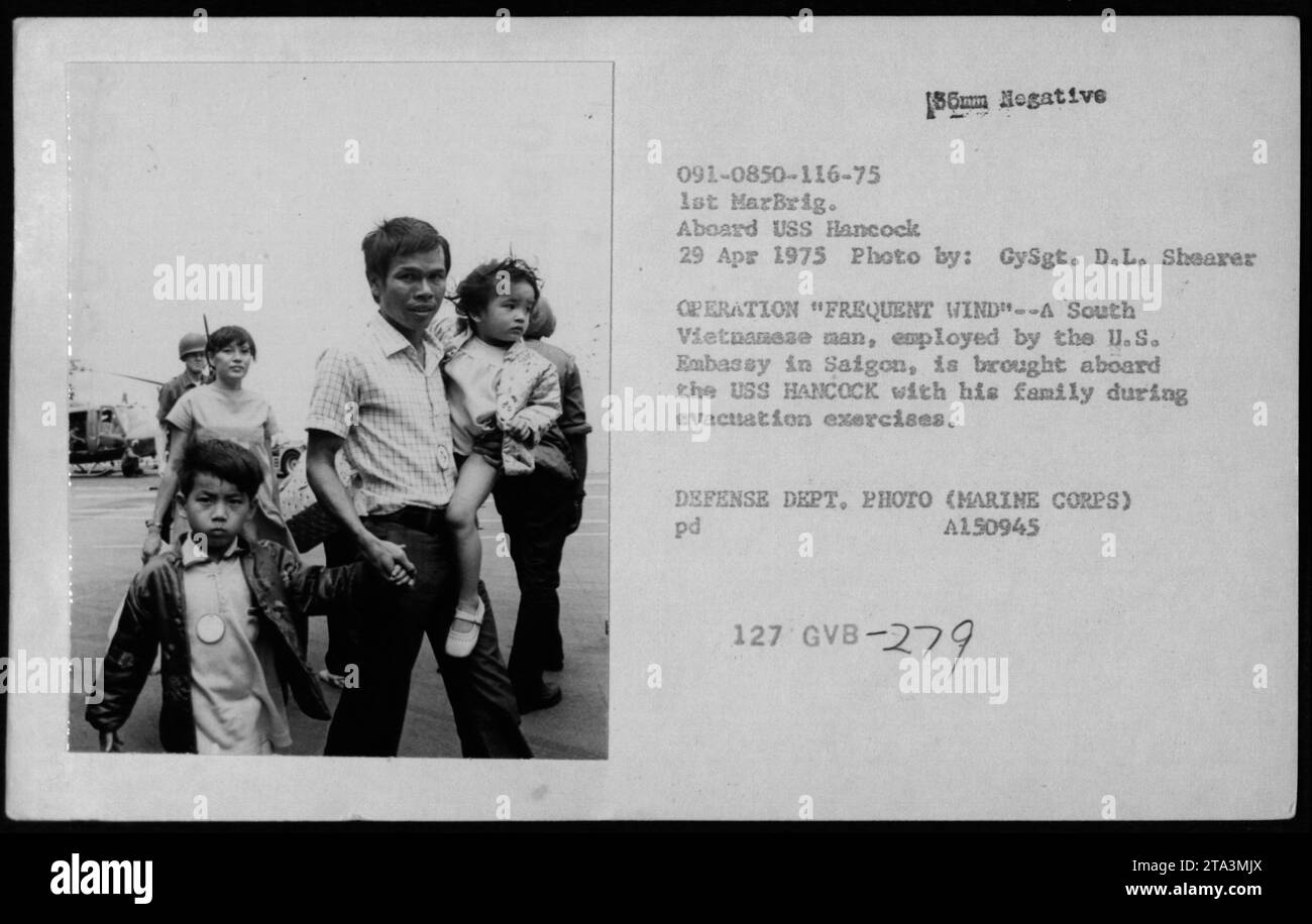 Ein südvietnamesischer Mann, der von der US-Botschaft in Saigon beschäftigt war, besteigt die USS Hancock mit seiner Familie während der Evakuierungsübungen der Operation Frequent Wind am 29. April 1975 als Teil der amerikanischen Militäraktivitäten im Vietnamkrieg. Stockfoto
