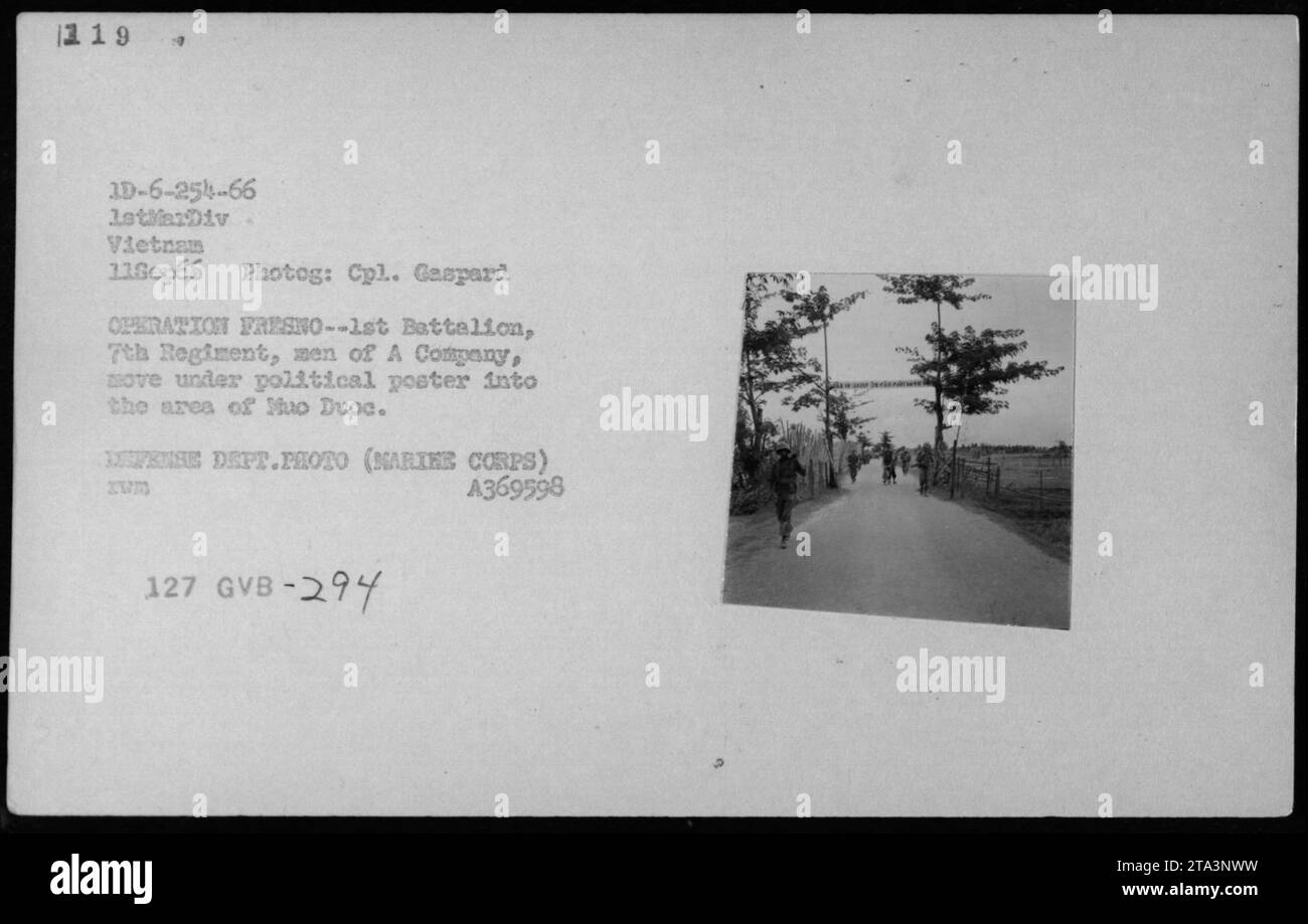 Marines aus Einer Kompanie, 1. Bataillon, 7. Regiment, bewegen sich unter einem politischen Propagandaplakat in Tuo Duoc, Vietnam, während der Operation Fresno am 11. September 1966, fotografiert von Corporal Gaspard. Stockfoto